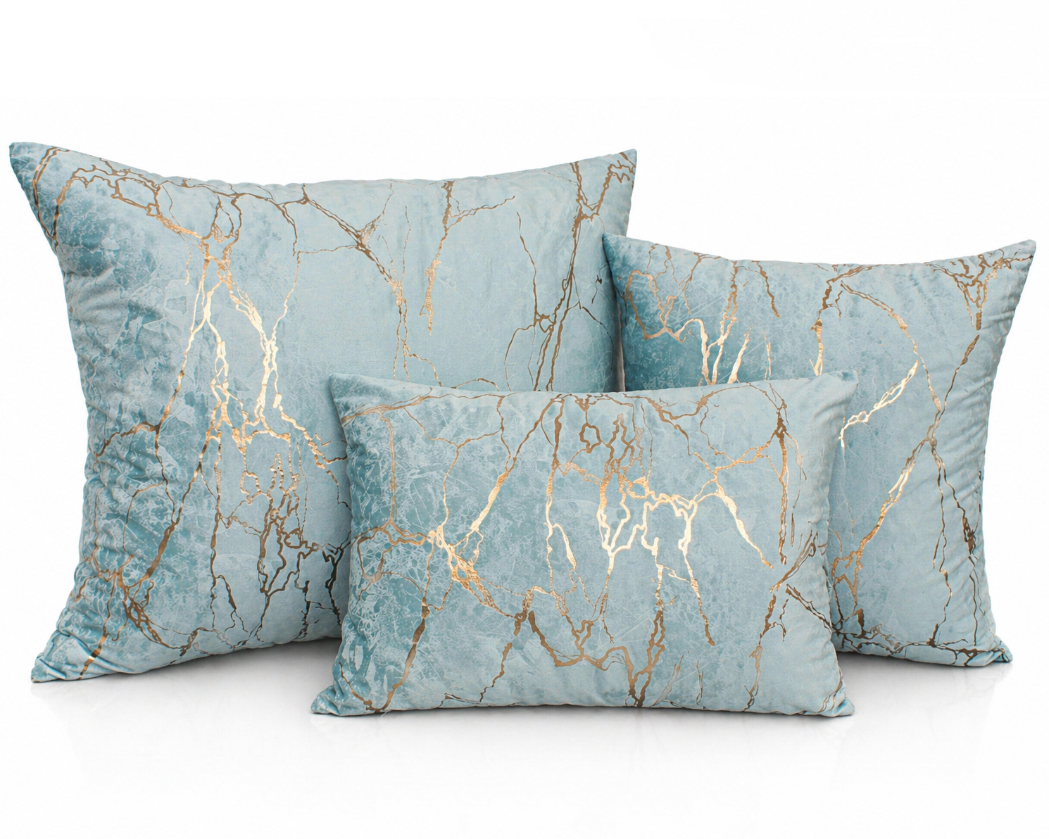 Três almofadas azuis com padrão dourado sobre fundo branco