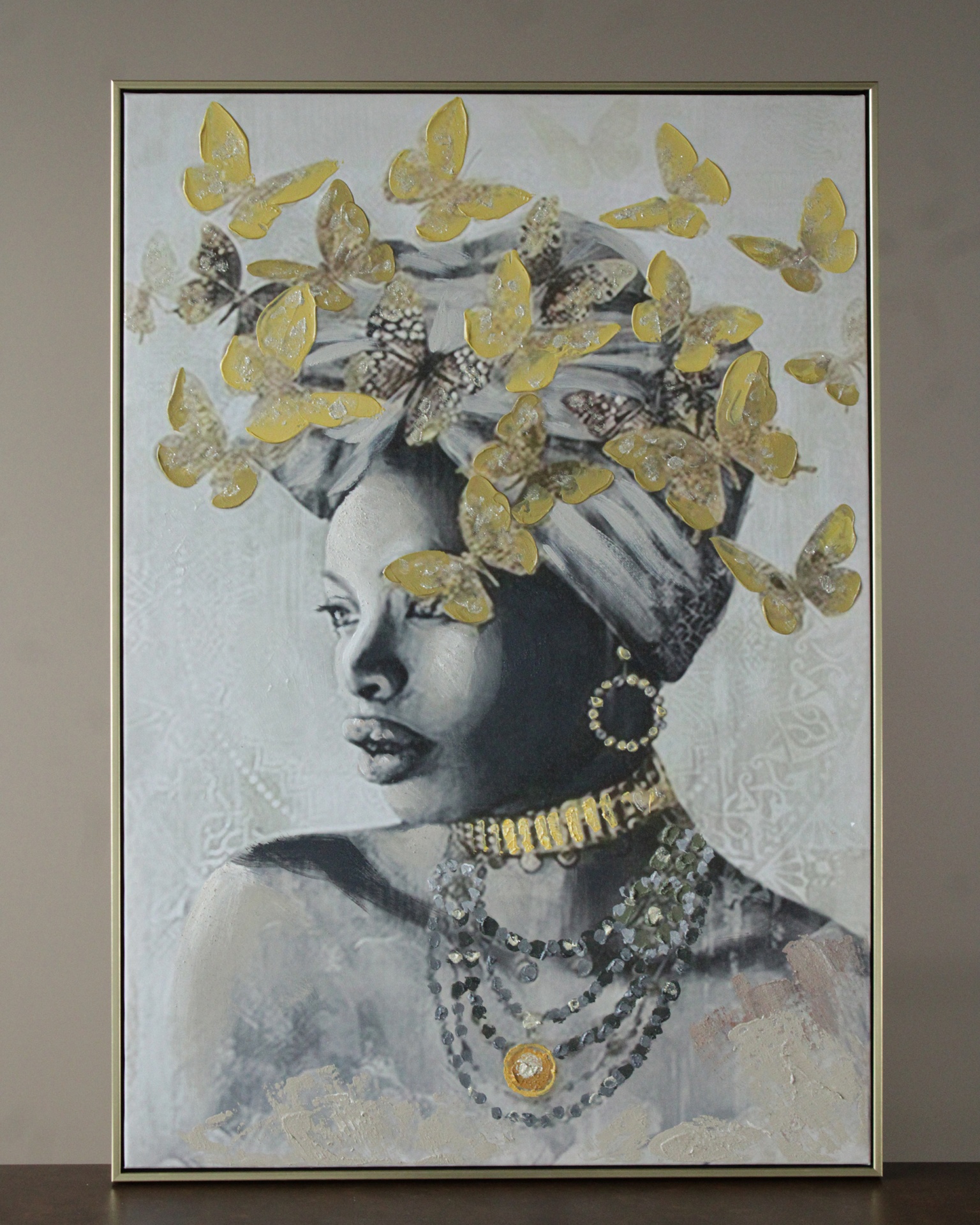 Quadro pintado de mulher com turbante e borboletas douradas.