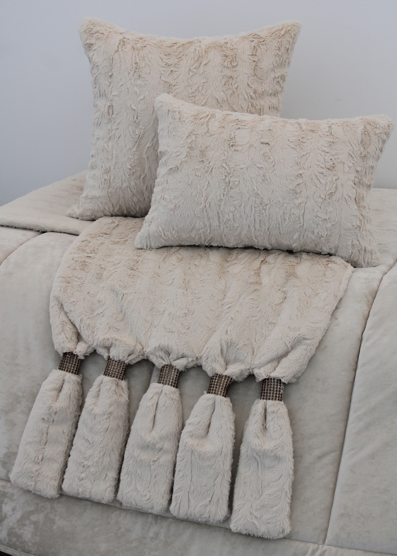 almofadas peludas e manta bege com tasséis