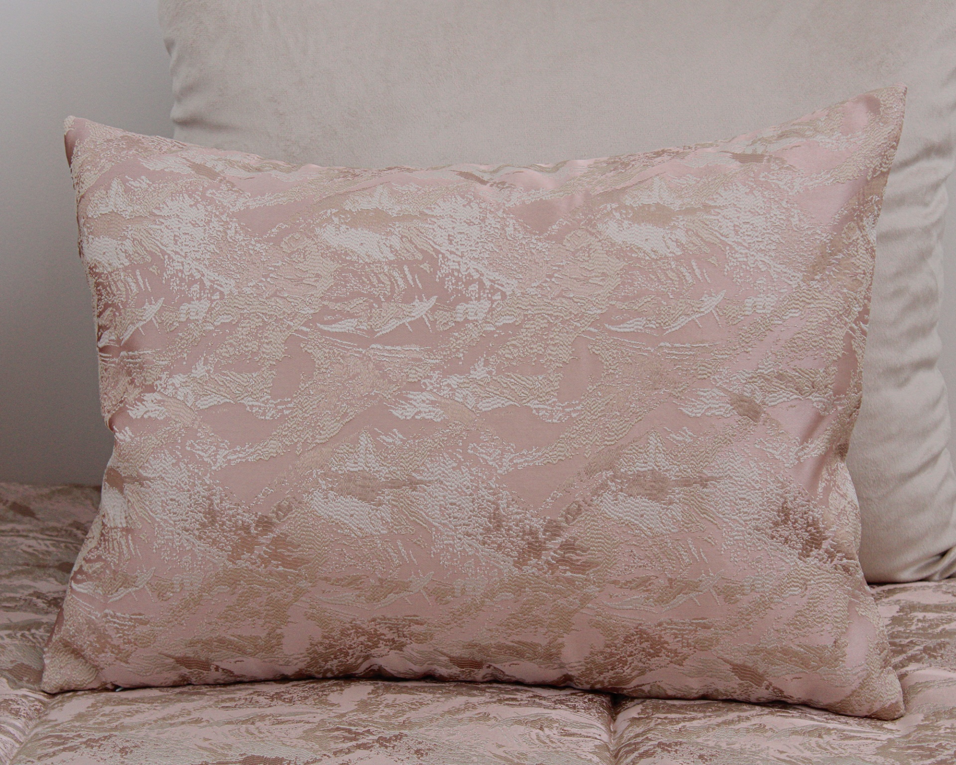 Almofada rosa claro com padrão jacquard bege e almofada bege lisa ao fundo
