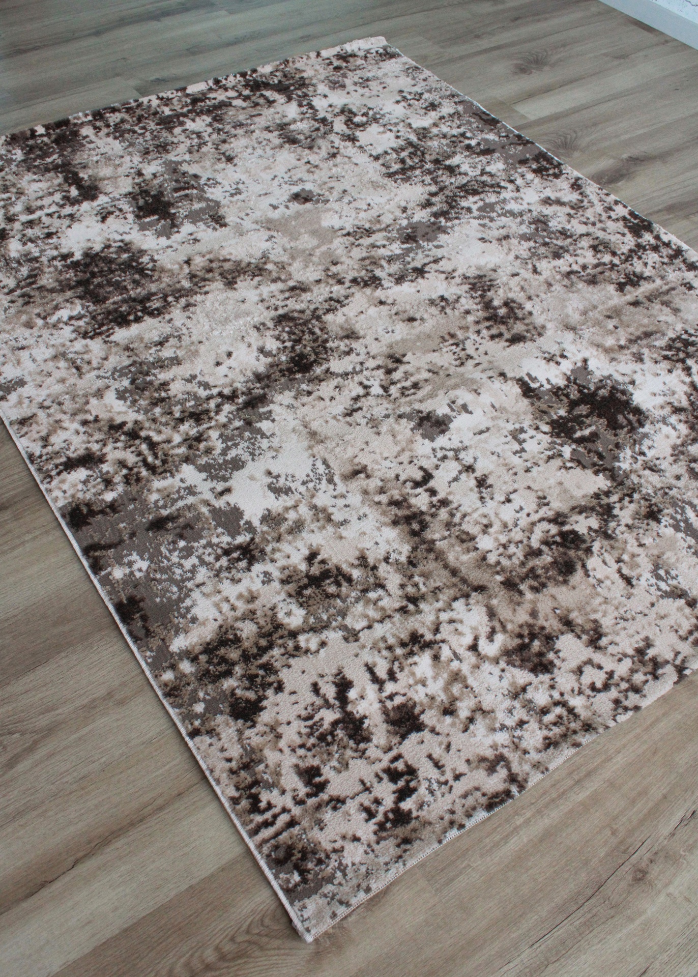 Tapete retangular com padrão abstrato em tons de bege, castanho e branco