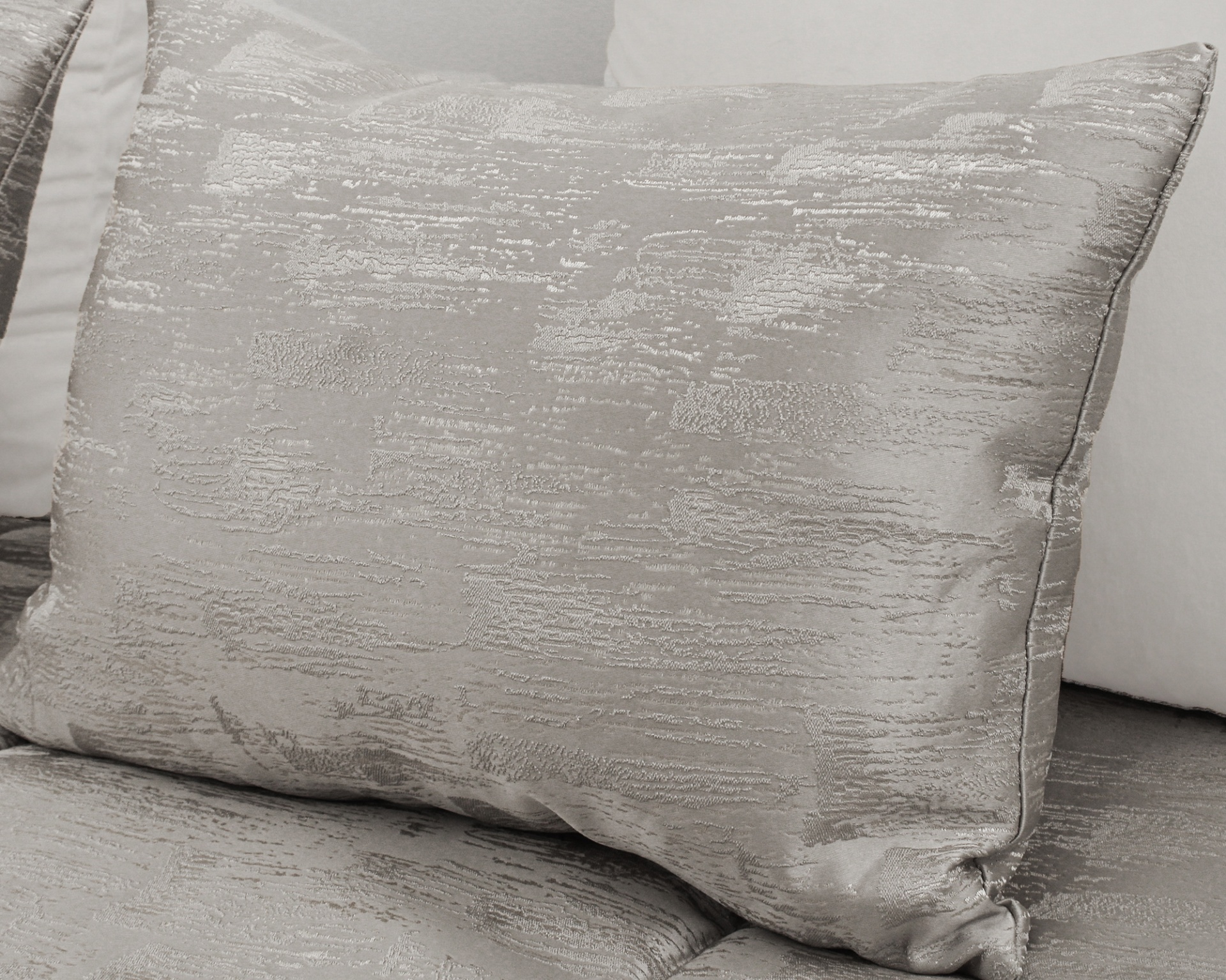 Almofada prateada com textura brilhante em ambiente interior