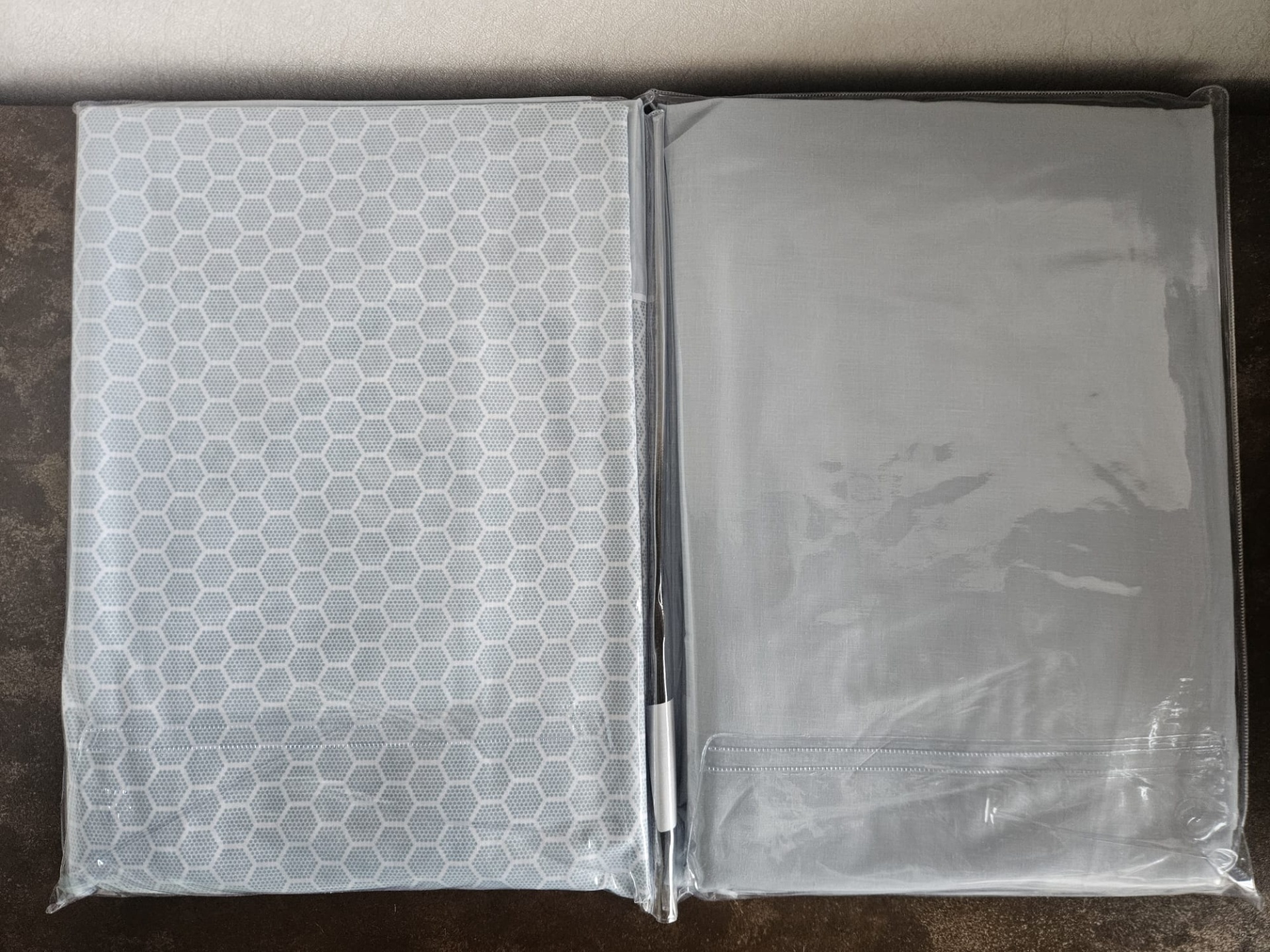 Duas capas protetoras transparentes para roupa, uma com padrão hexagonal e outra lisa.