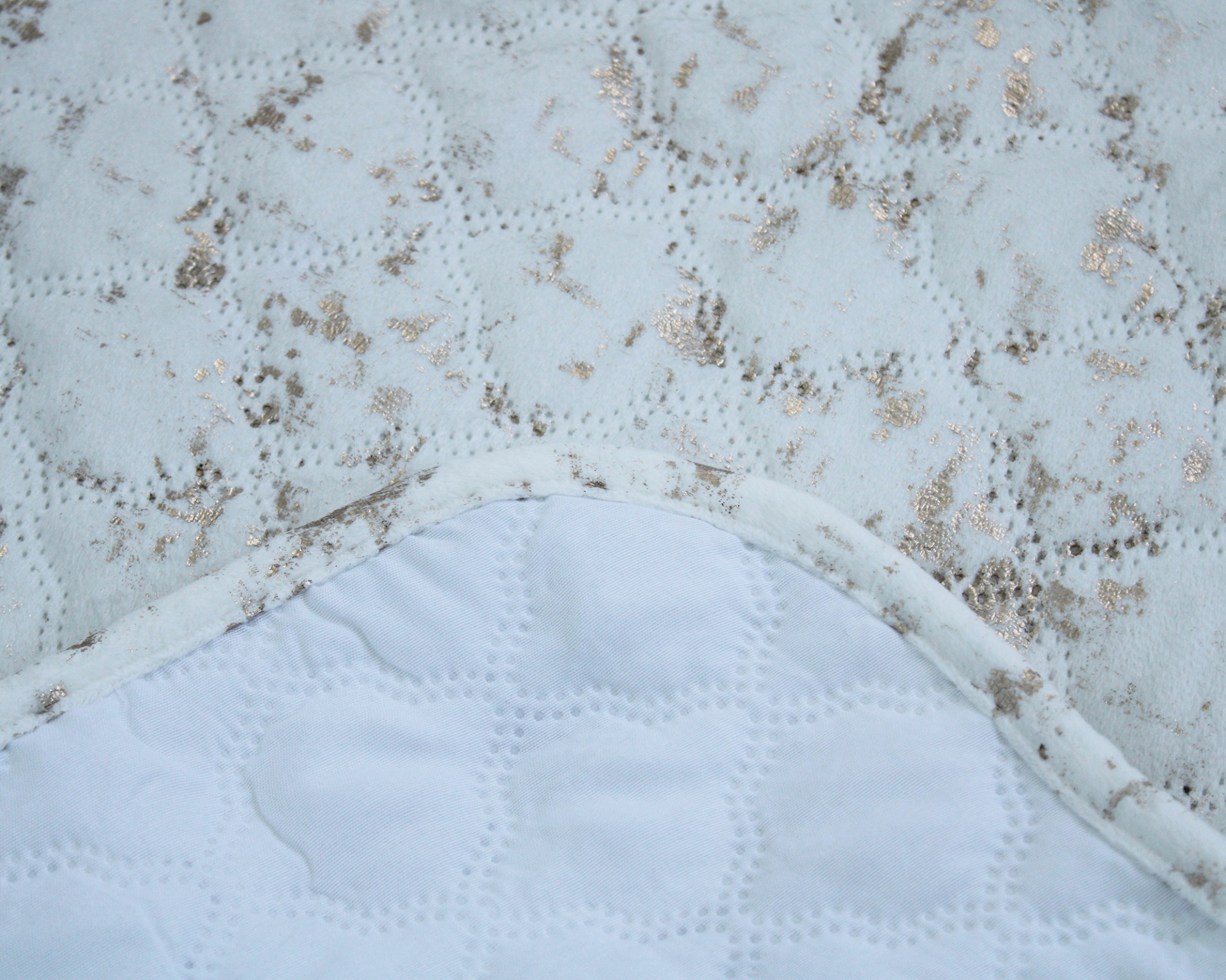 Edredão branco com padrão de renda dourada e interior acolchoado branco