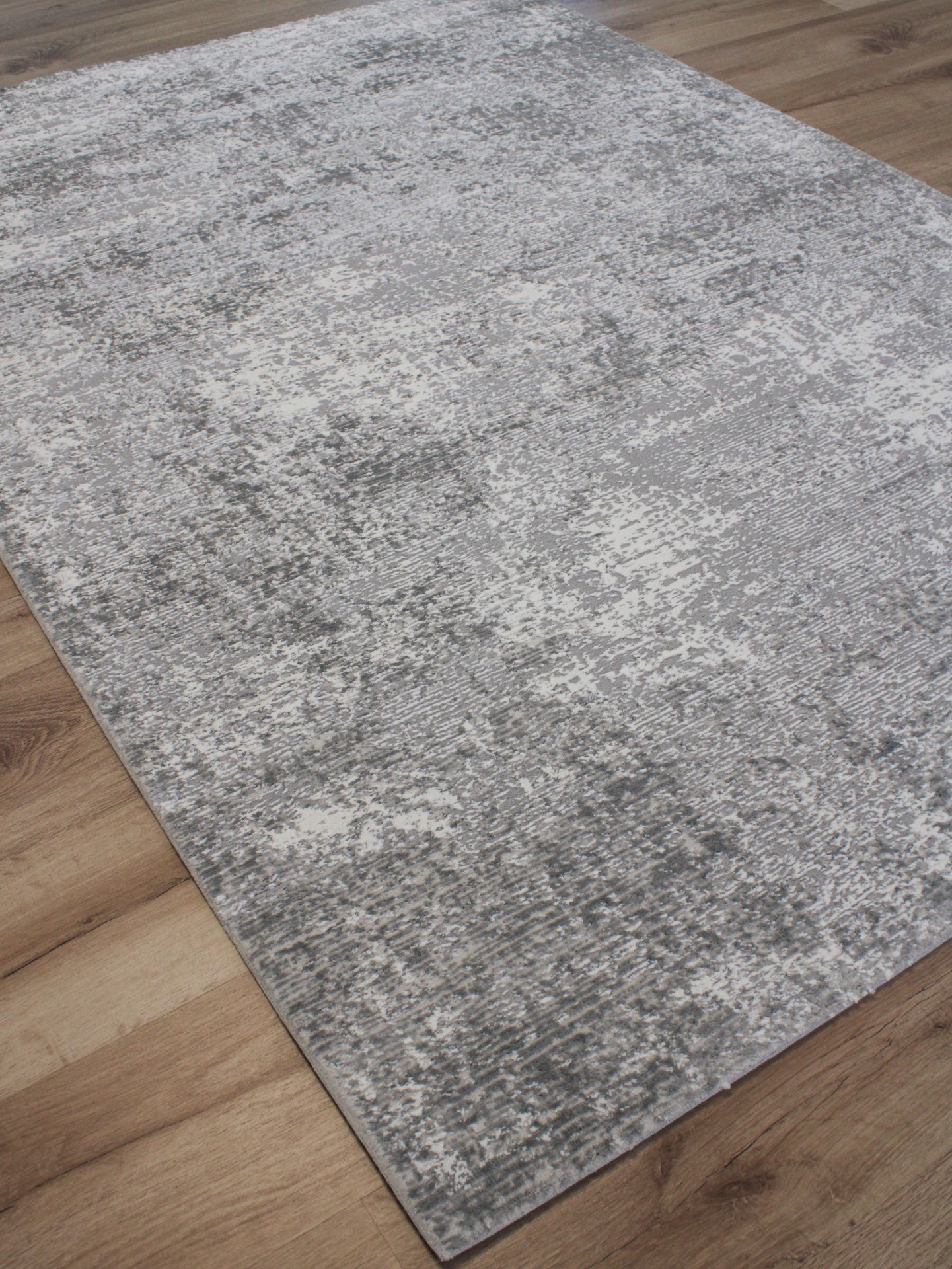 Tapete cinzento abstrato sobre piso de madeira