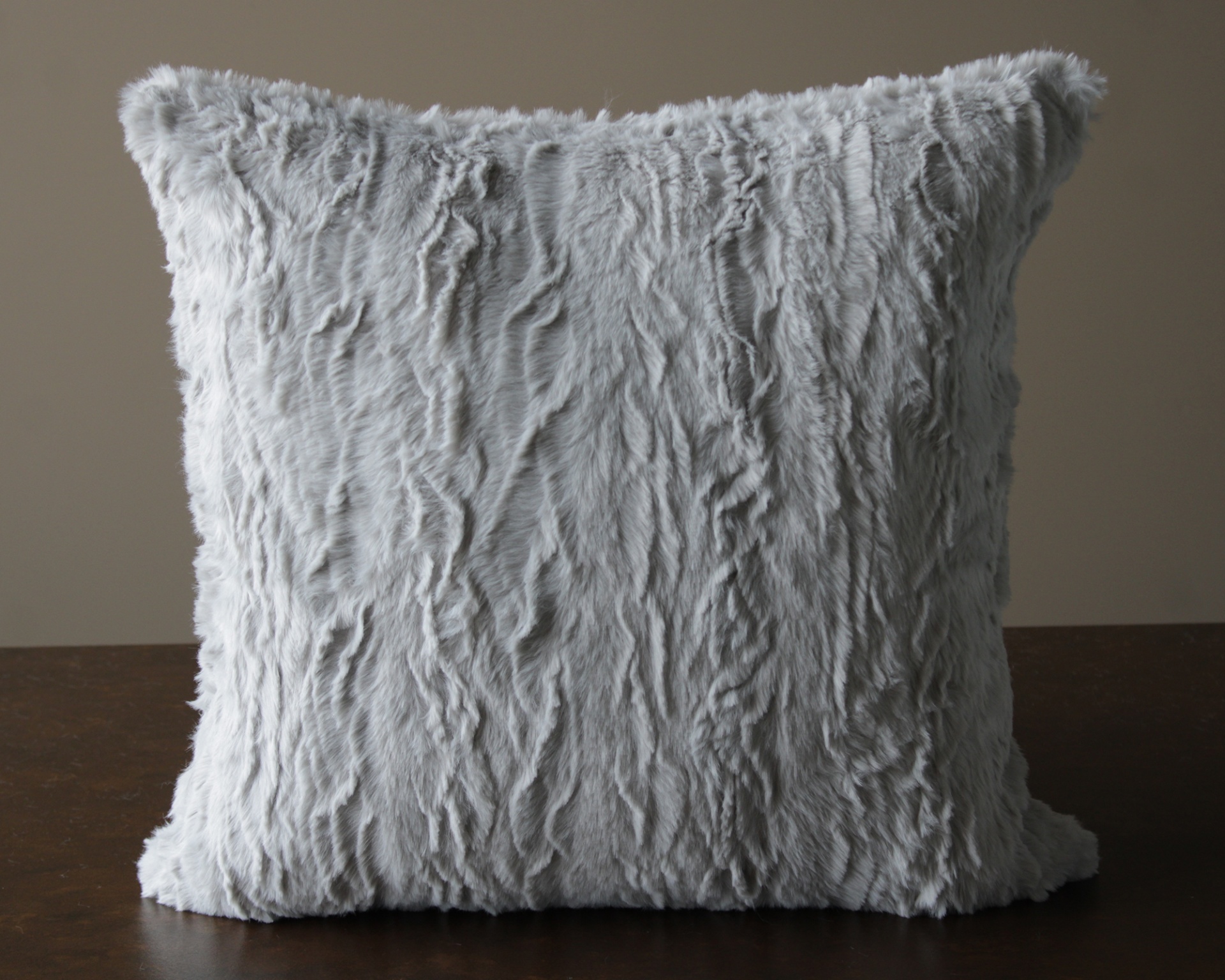 Almofada quadrada cinzenta de pelo macio com textura irregular