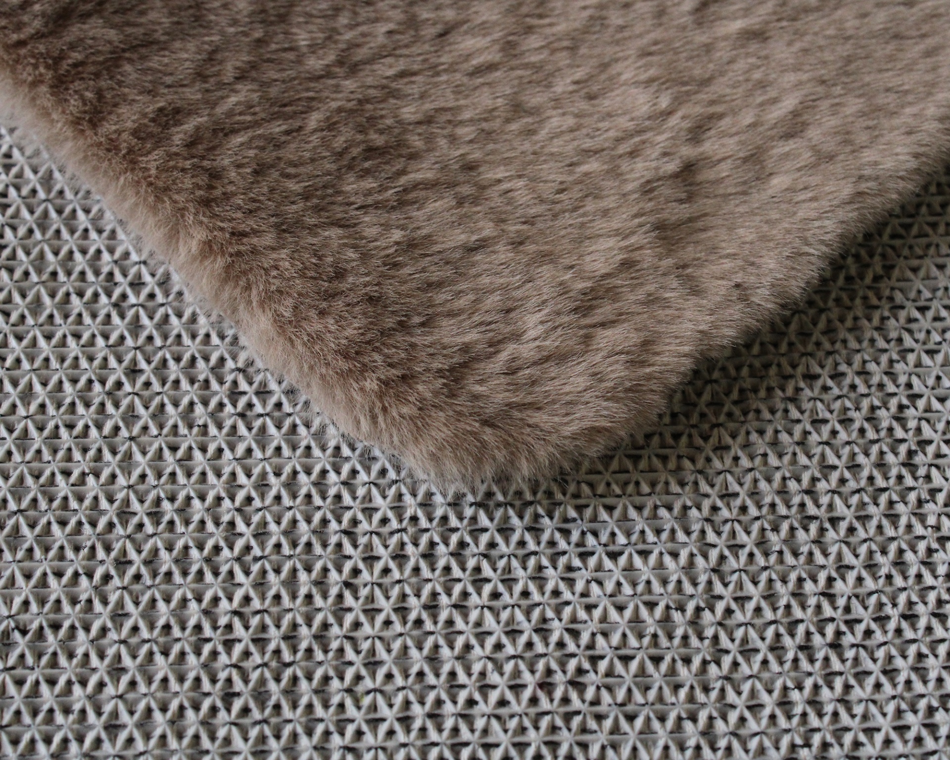 Tapete ou manta castanha sobre superfície cinzenta texturada