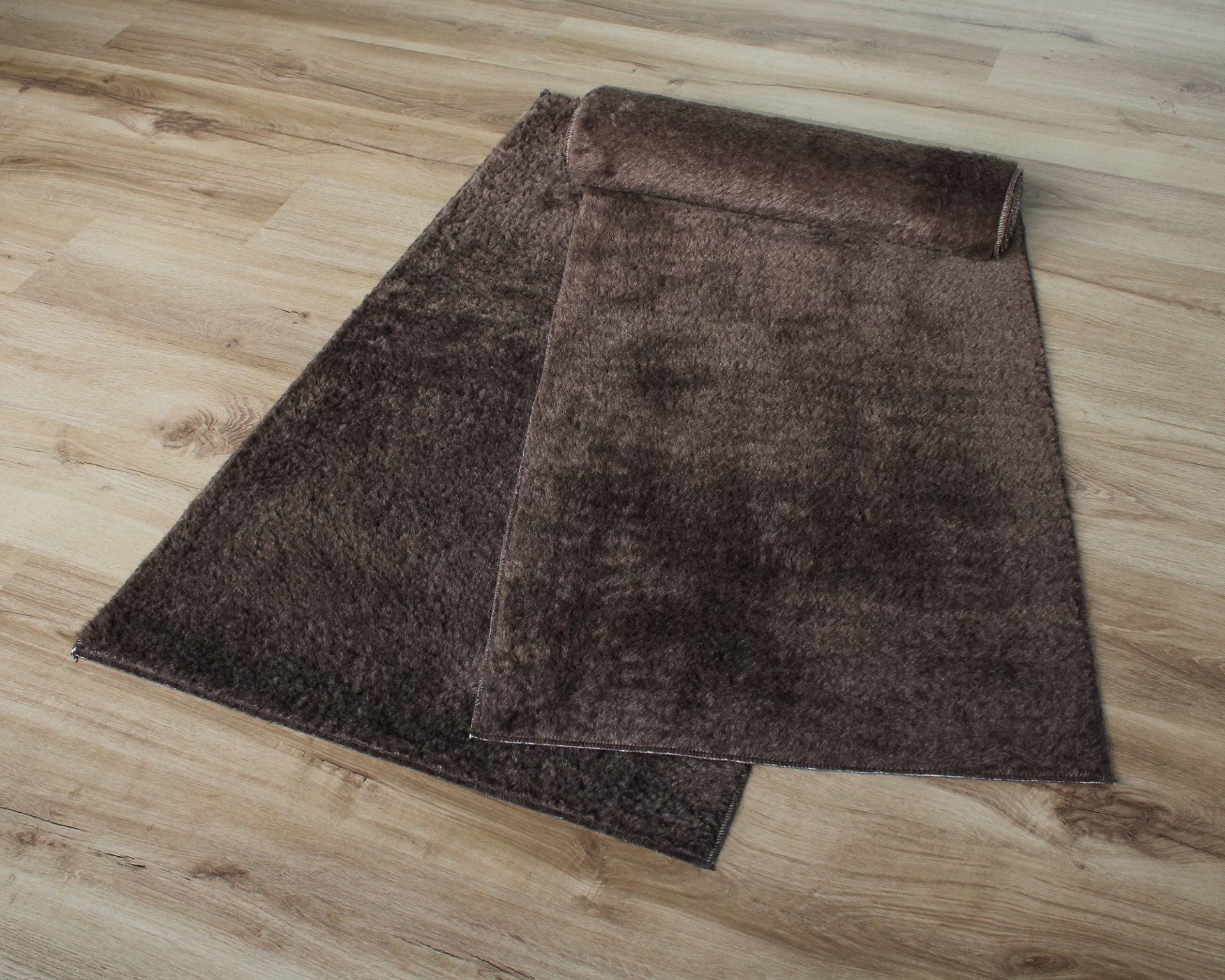 tapete castanho felpudo sobre chão madeira