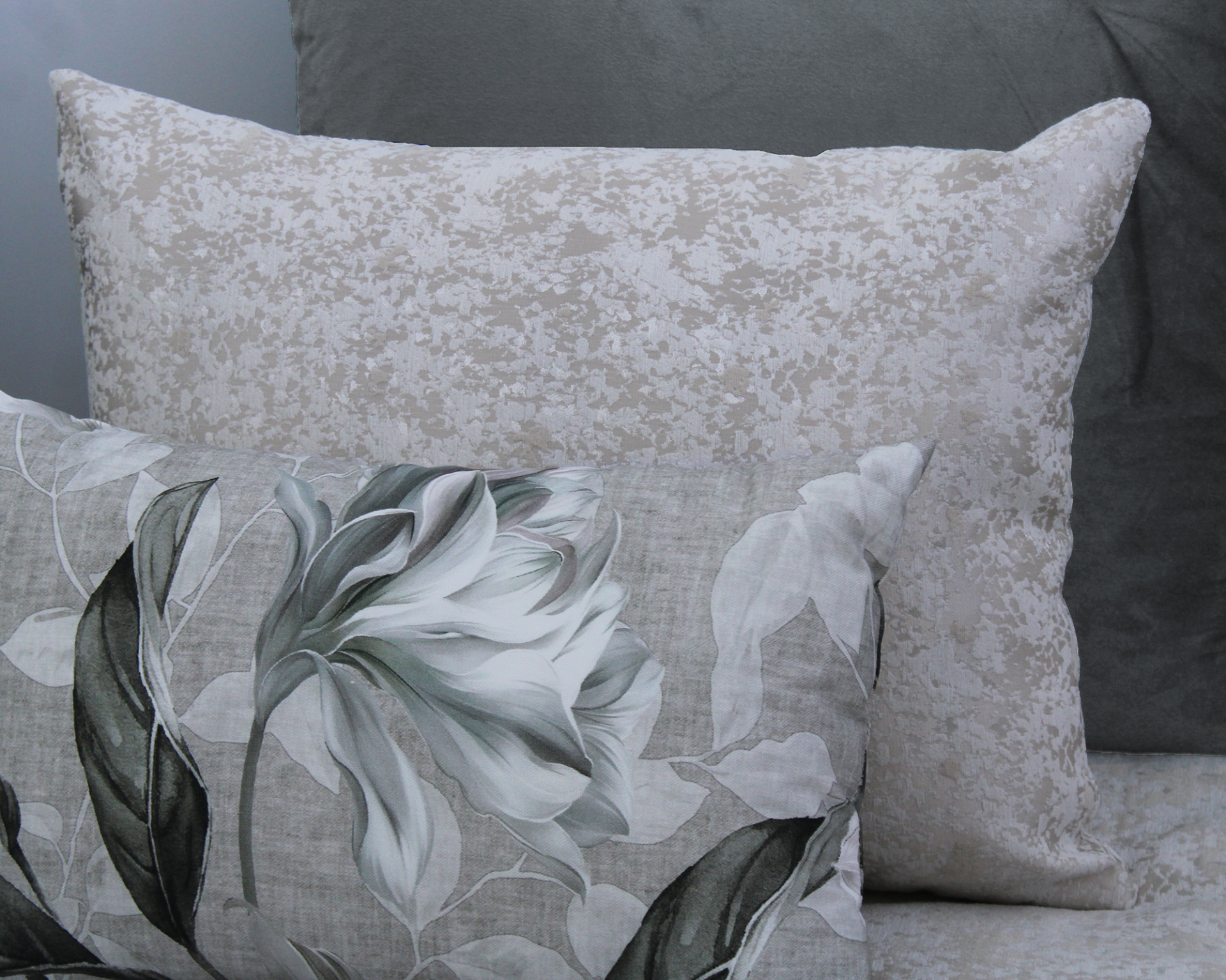 Almofadas com padrões florais e abstratos em tons de cinza e branco