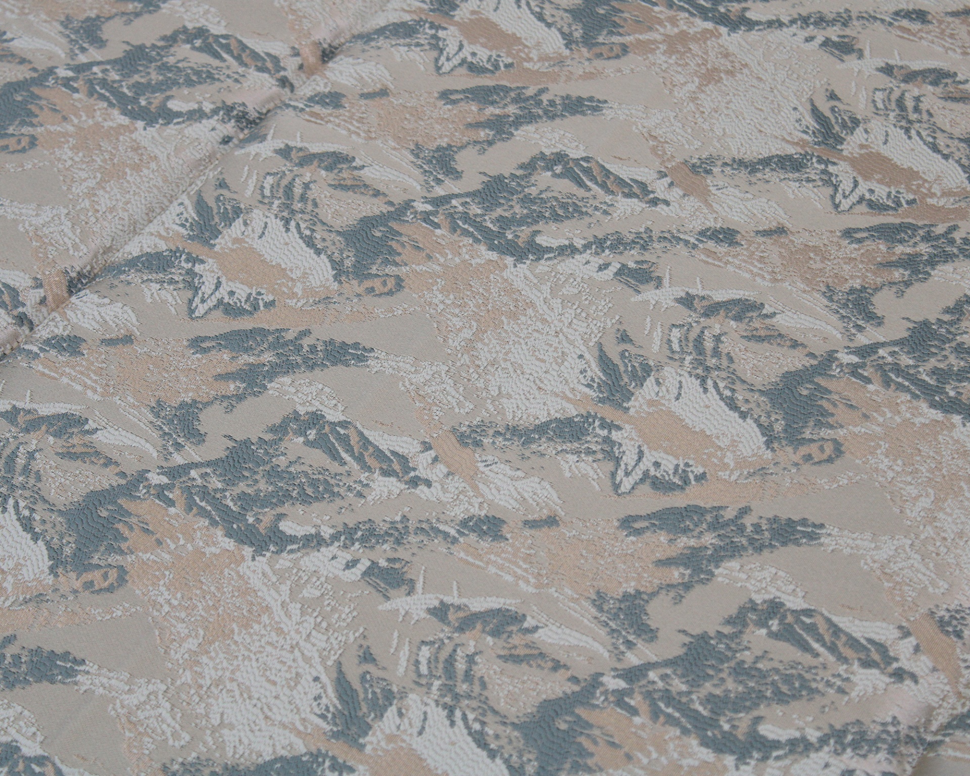 Tecido jacquard com padrão abstracto em azul, bege e branco e textura em relevo