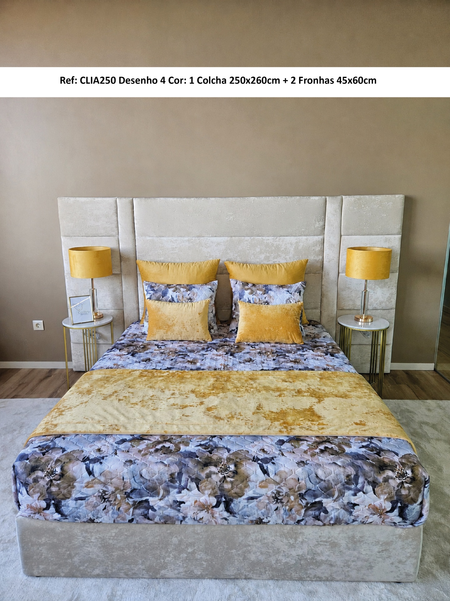 Cama com colcha floral azul e amarelo, almofadas amarelas e cabeceira estofada bege