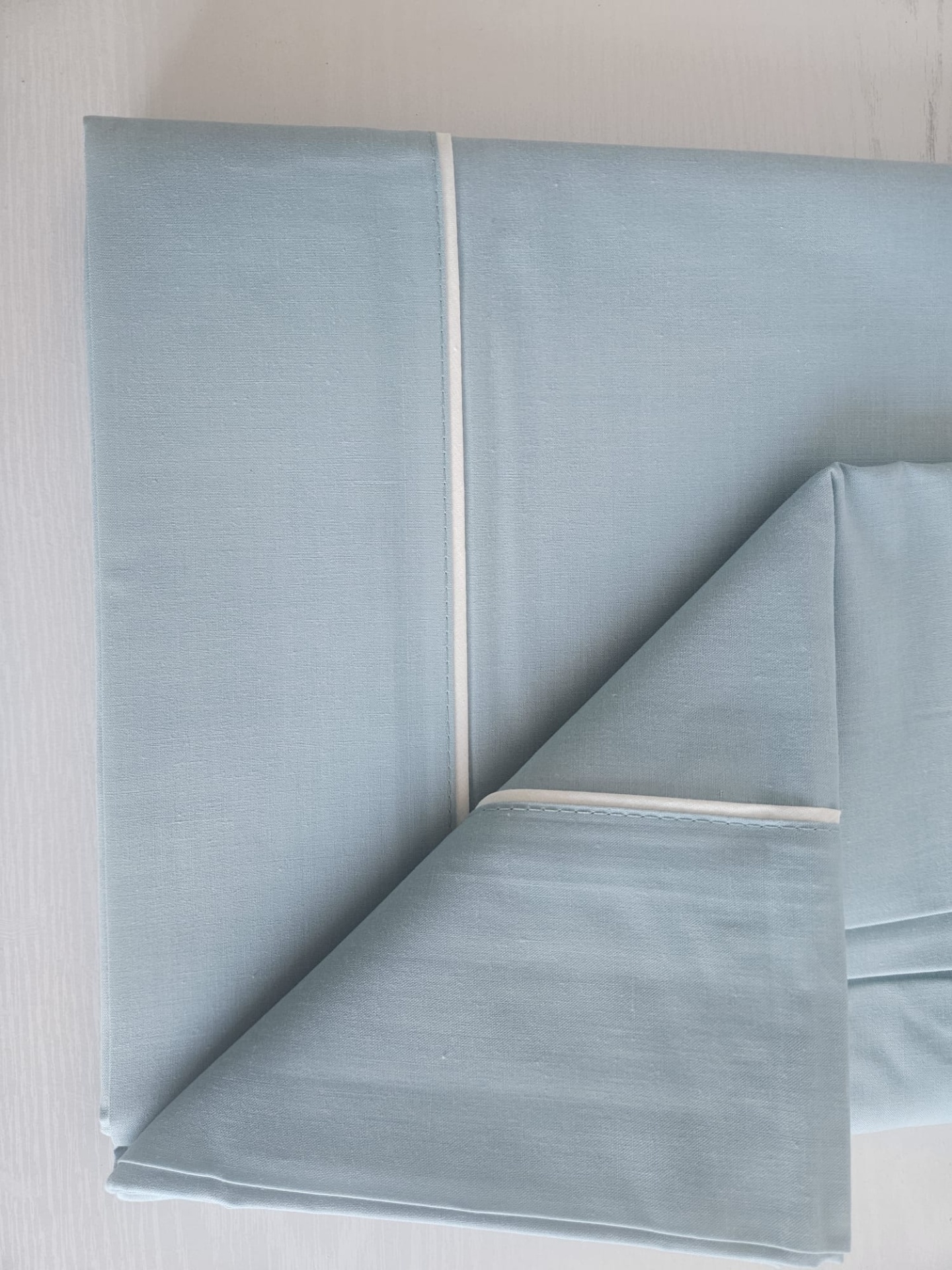 Lençol azul claro com detalhe branco