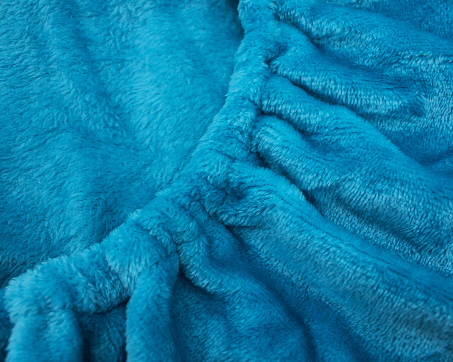 Tecido felpudo azul turquesa com textura suave e ondulações.