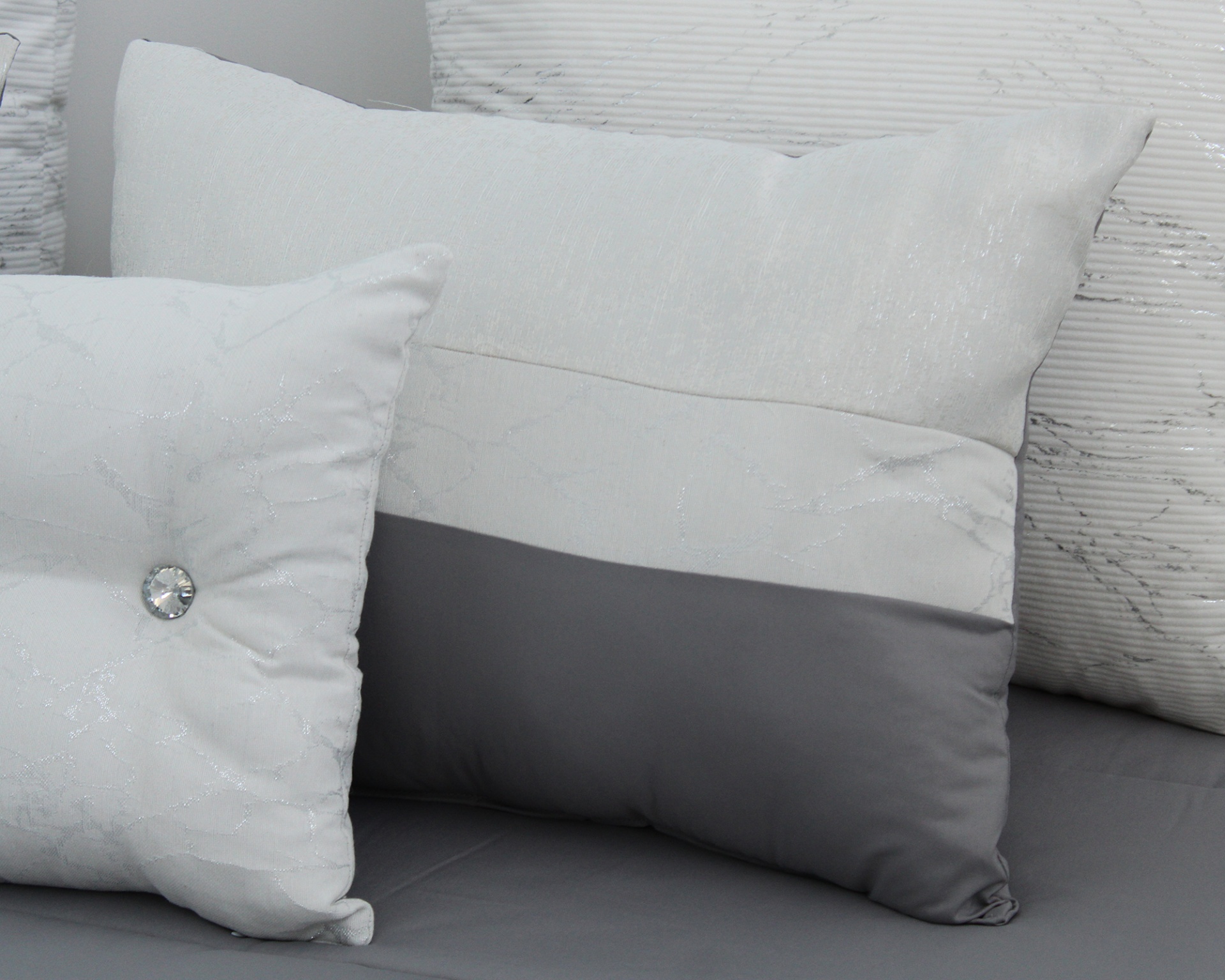 Conjunto de almofadas decorativas em branco e cinza com texturas variadas