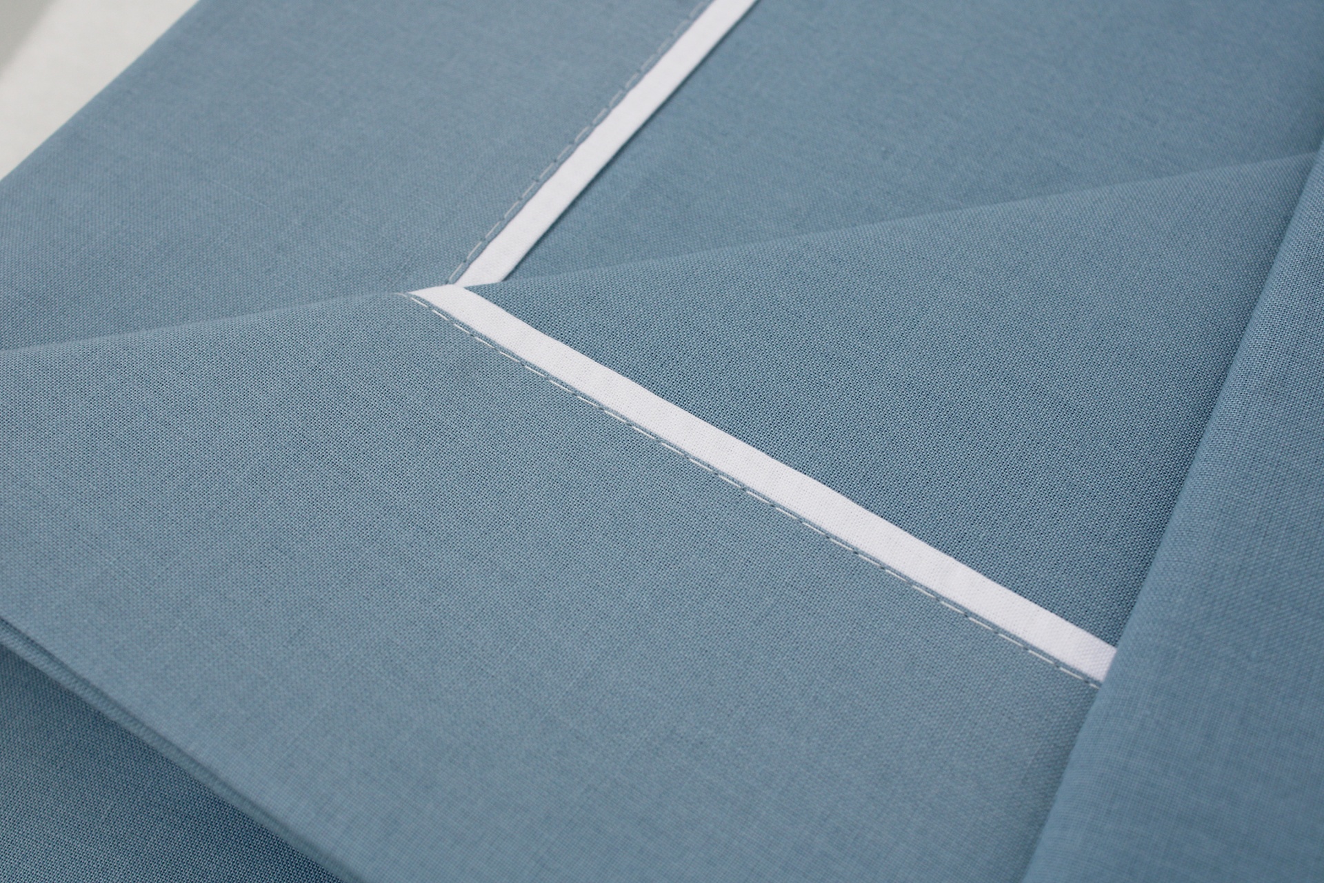 Pano de cozinha azul com faixa branca e textura lisa