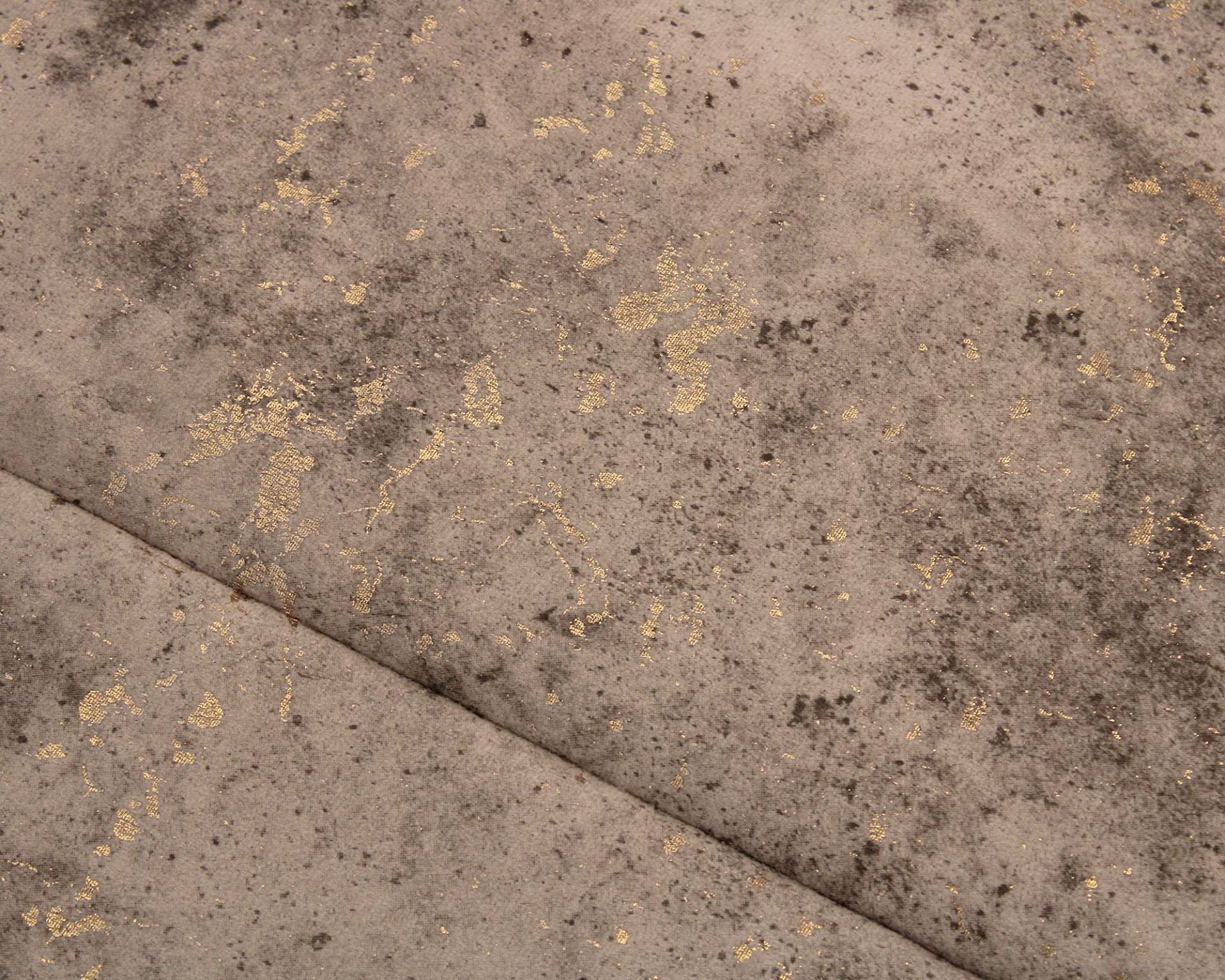 Tecido cinza bege aveludado com manchas escuras e detalhes dourados