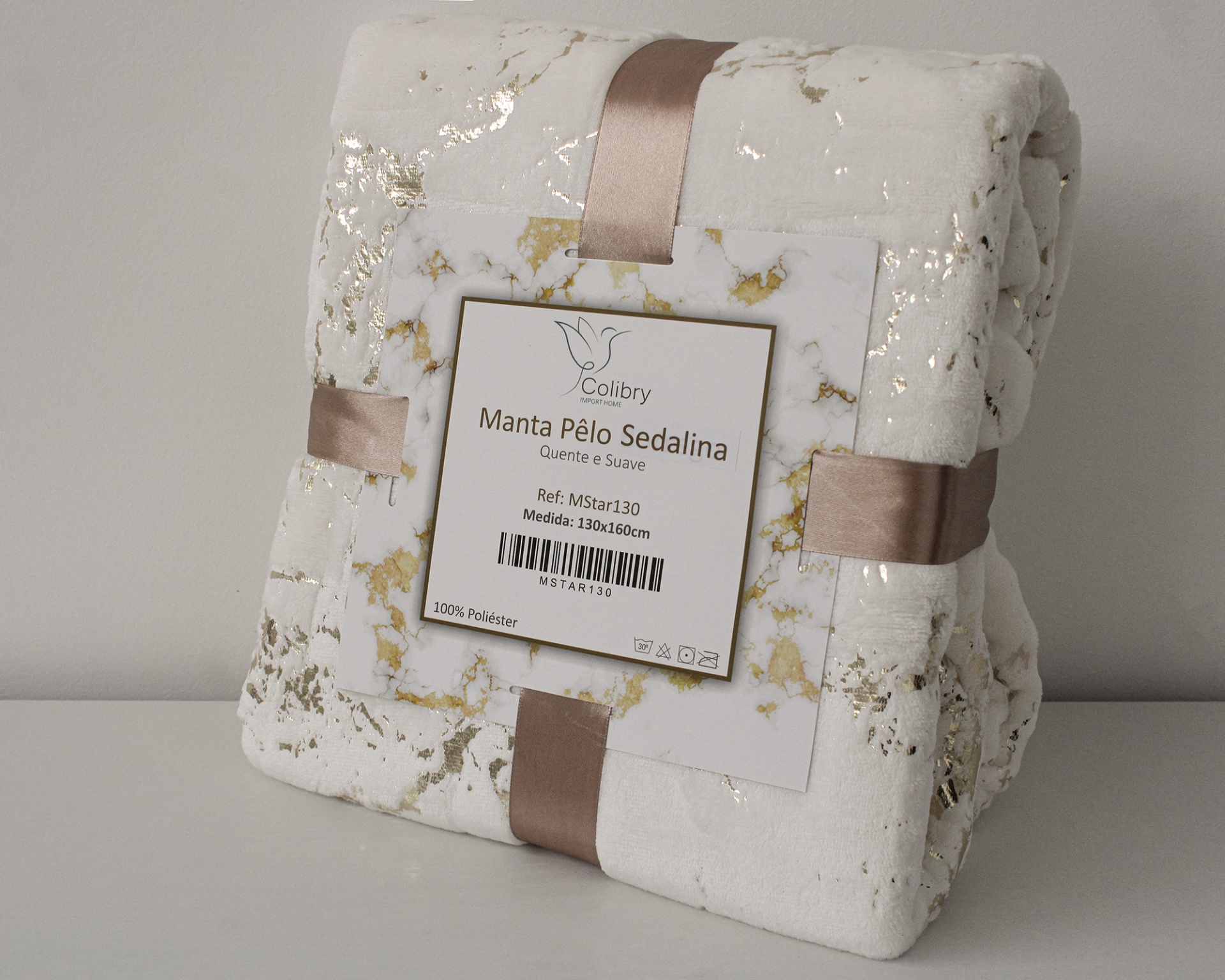 Manta branca com padrão marmoreado dourado em embalagem com fita cor de rosa e etiqueta