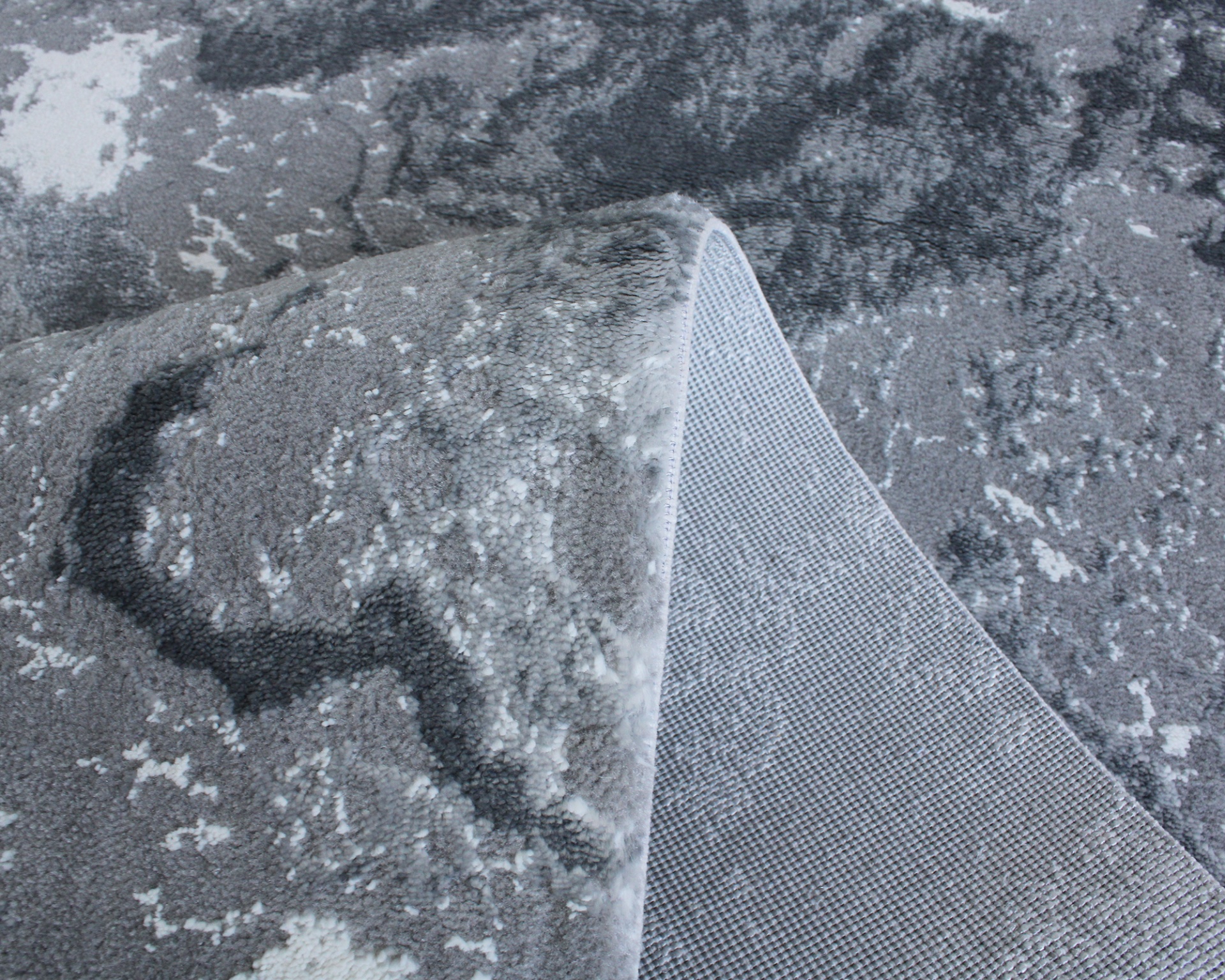 Tapete cinza com padrão e base antiderrapante visível