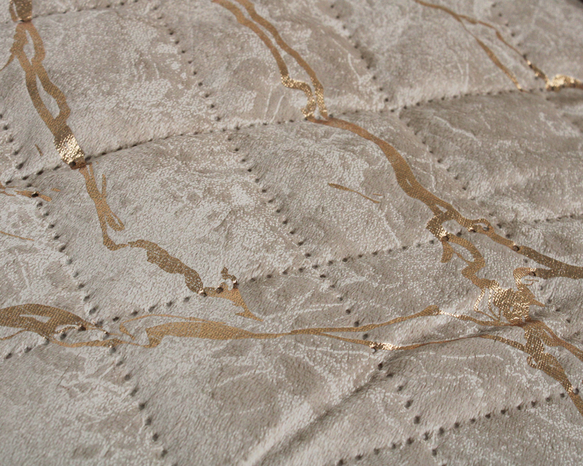 Tecido matelassado cinzento com linhas douradas entrelaçadas