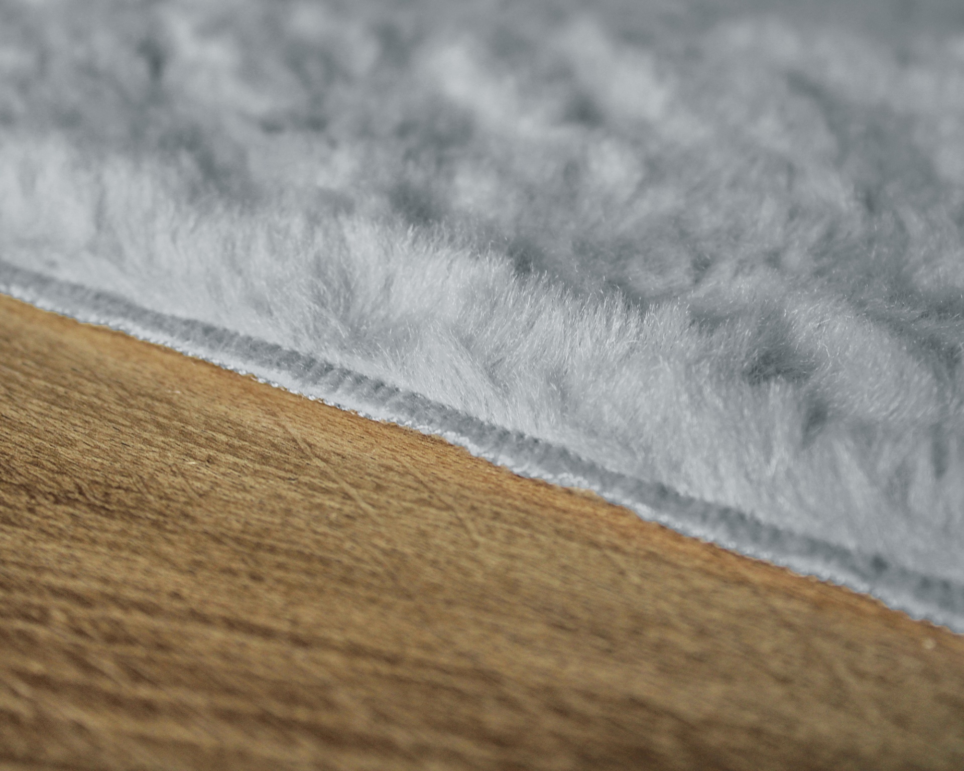 tecido felpudo cinza sobre madeira clara