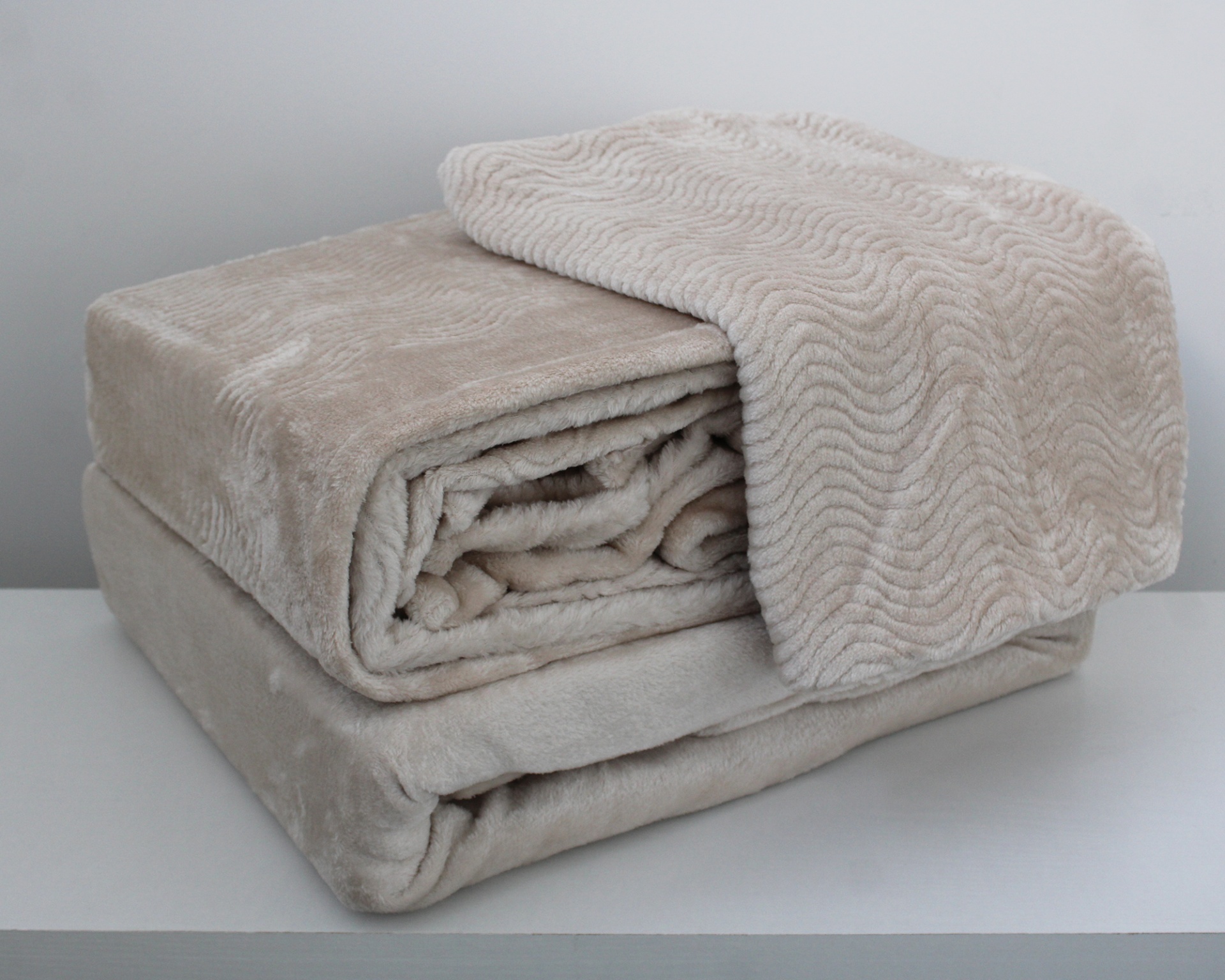 Cobertor ou manta beges com texturas ondulada e lisa