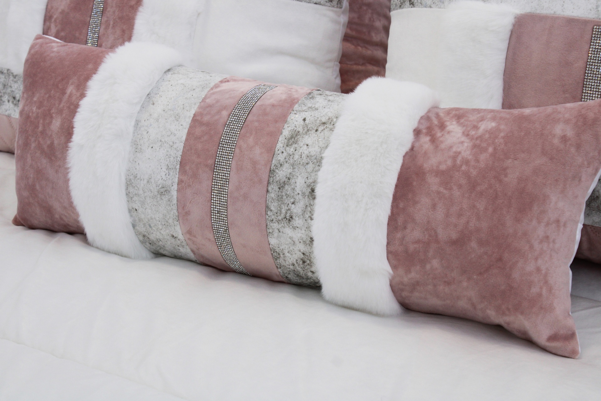 Almofadas decorativas rosa, branco e cinza com texturas variadas