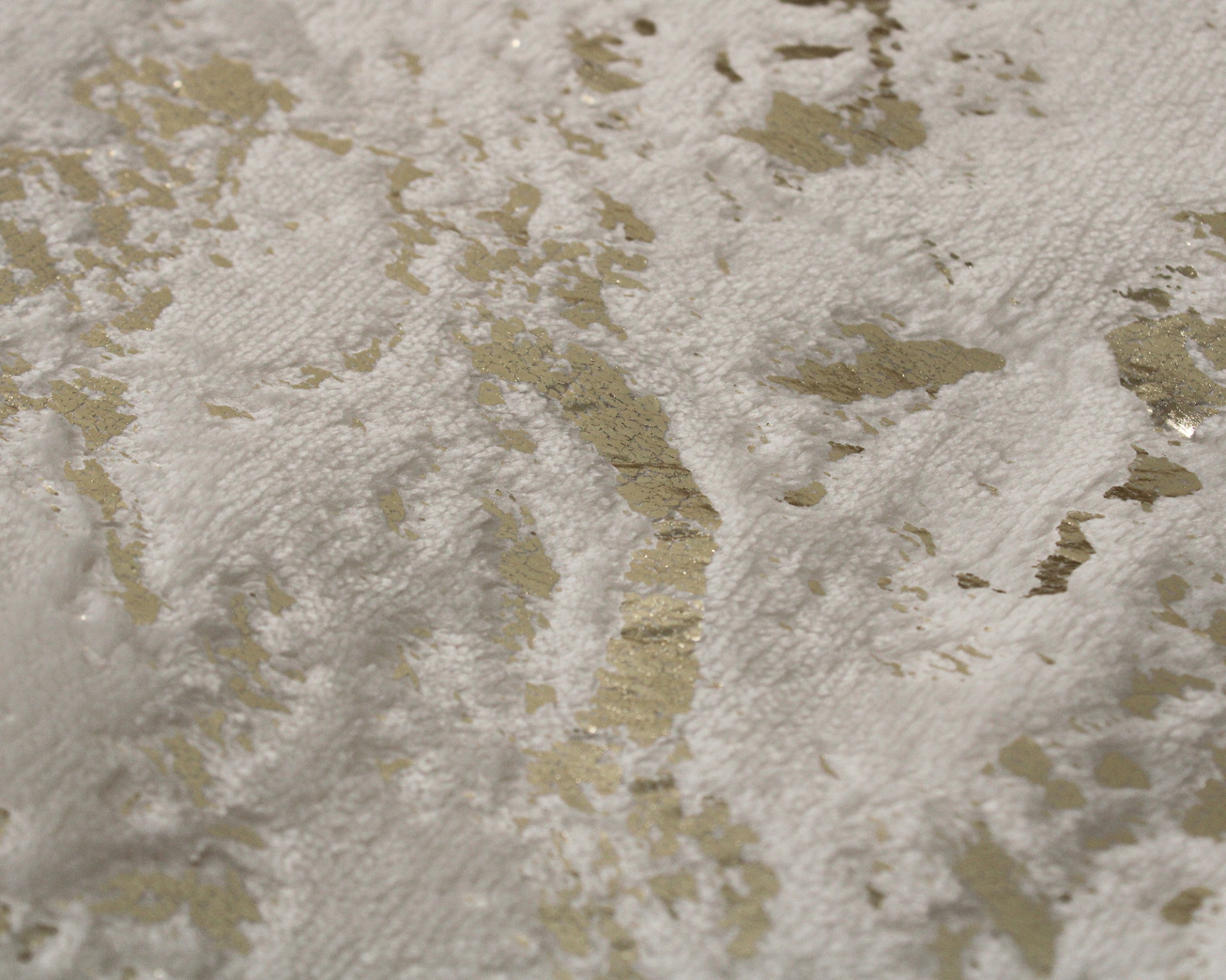 tecido branco com padrão texturizado e detalhes dourados