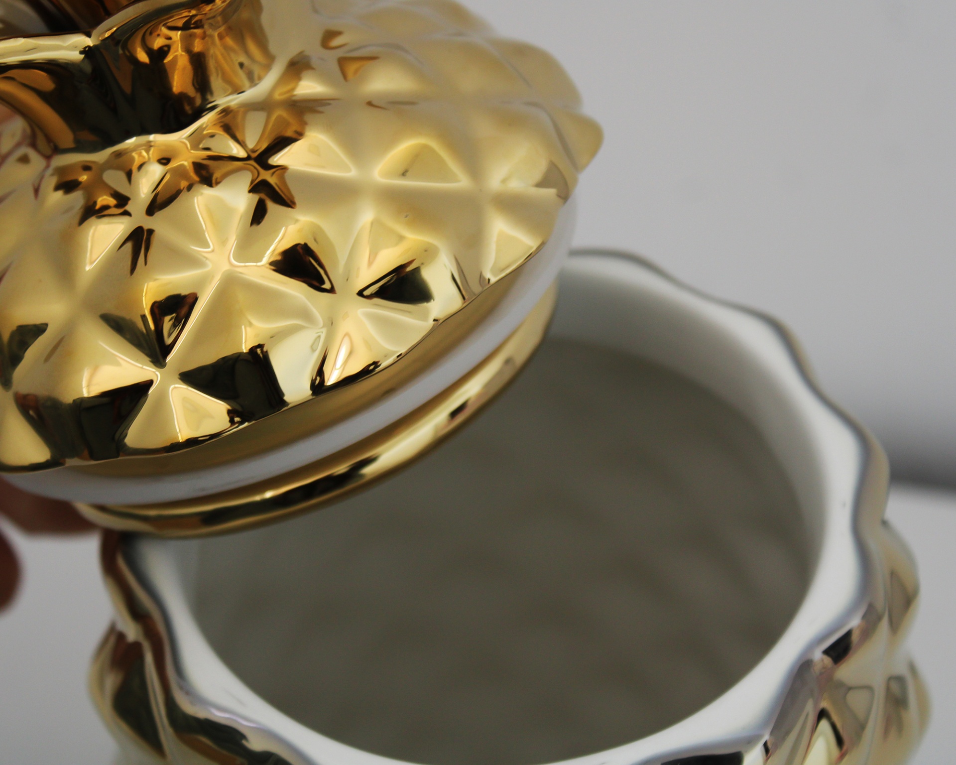 Pote decorativo branco com tampa dourada em relevo