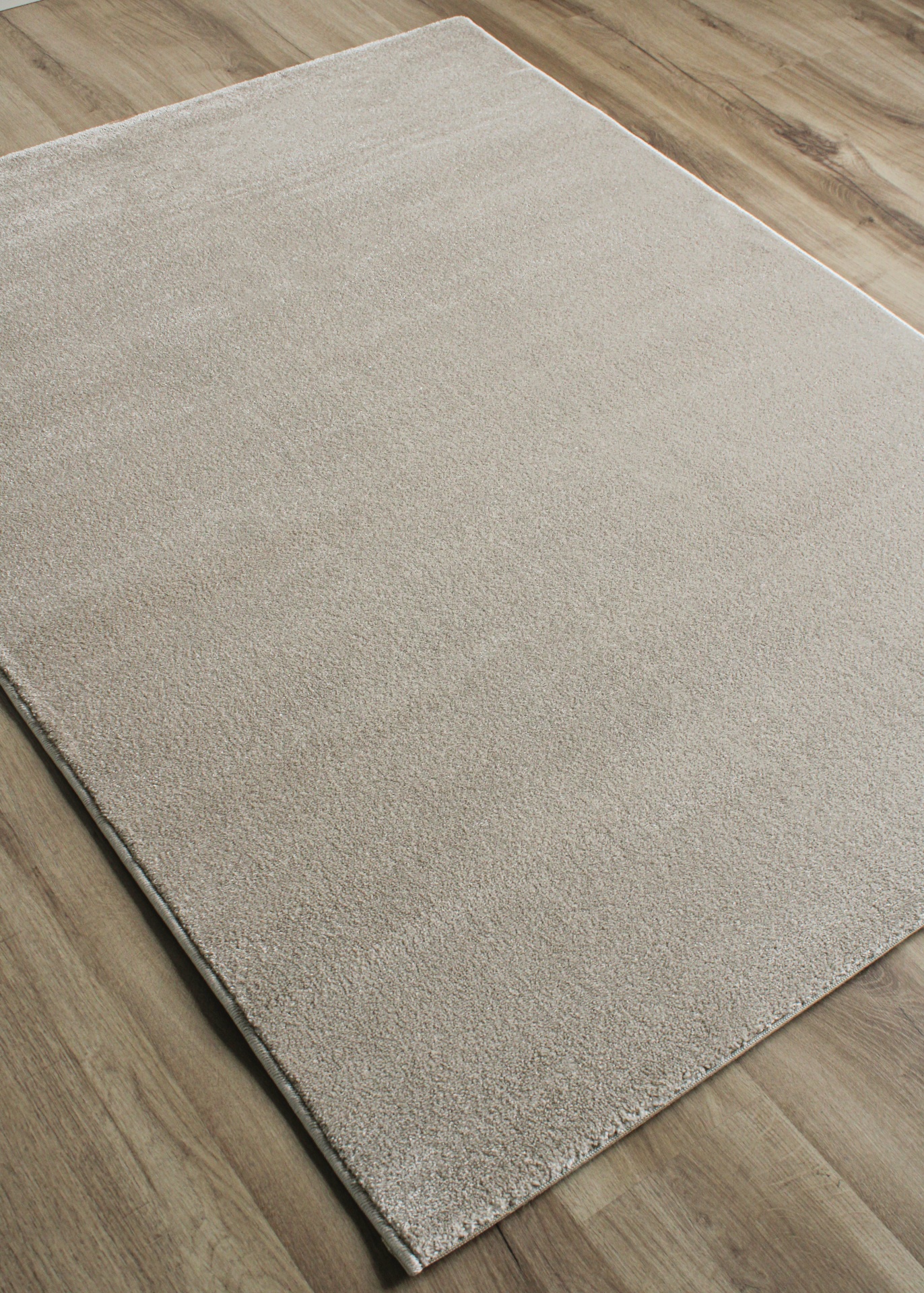 Tapete bege claro sobre chão de madeira clara