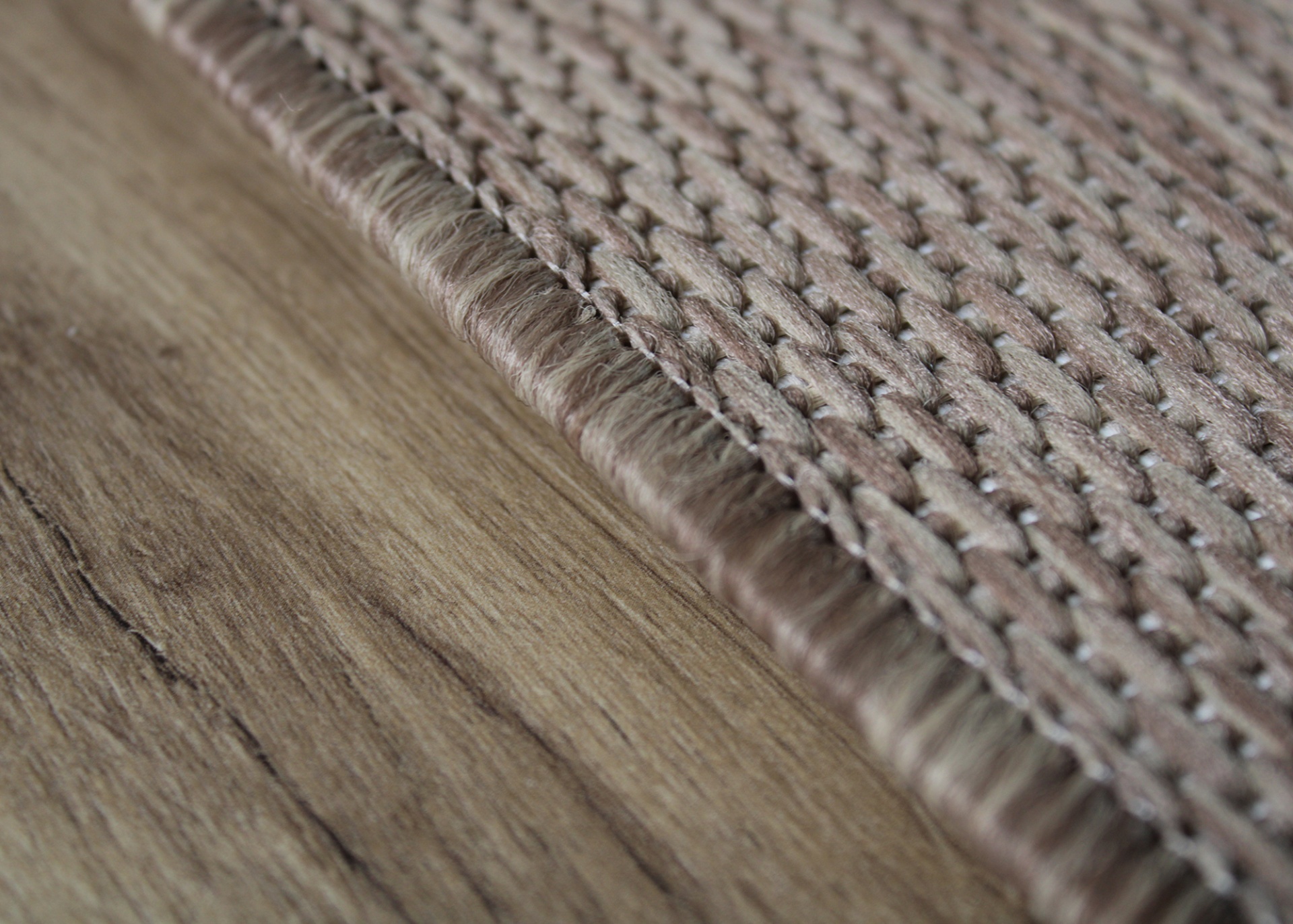 Tapete trançado bege sobre chão de madeira clara