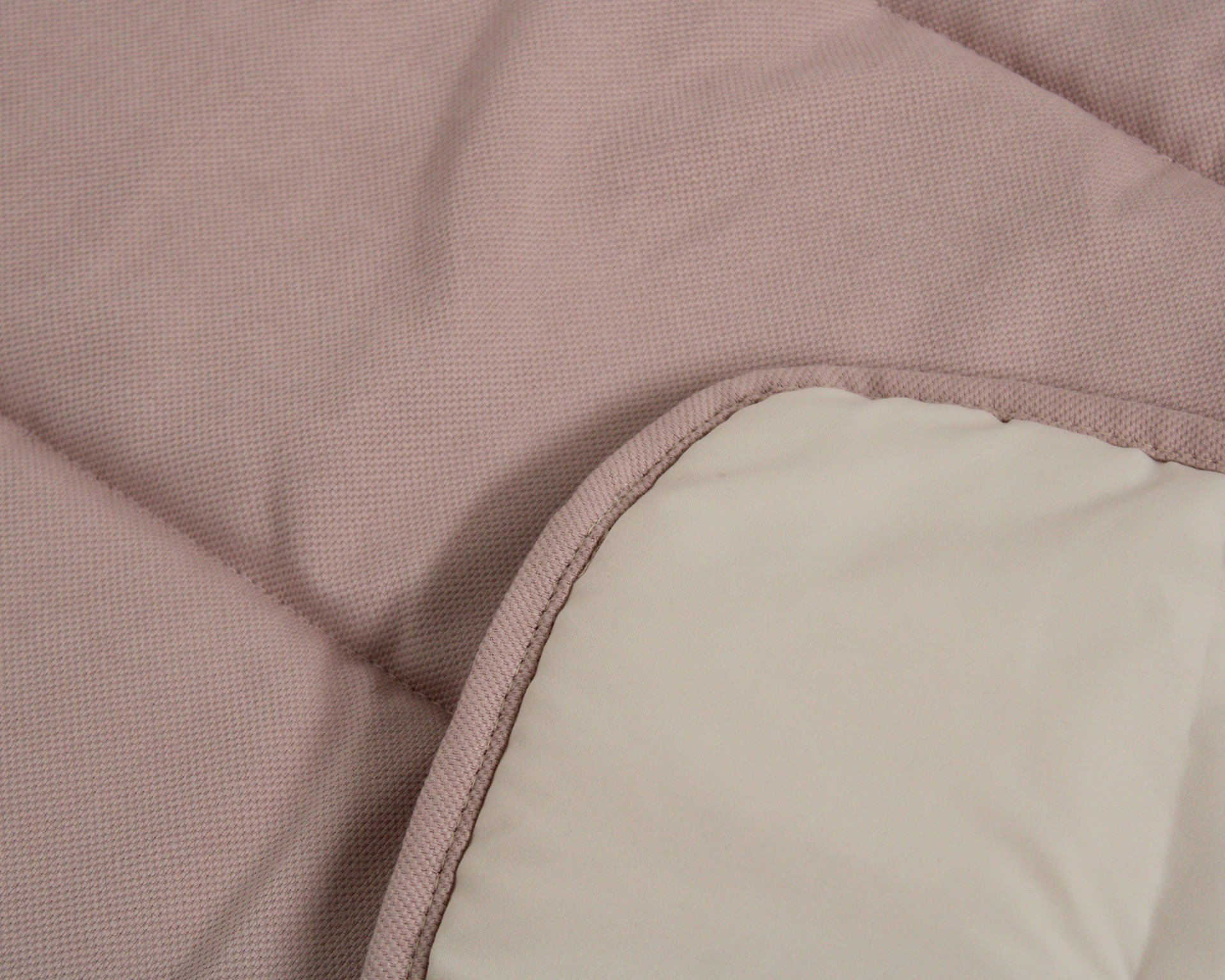 Colcha rosa claro com relevo acolchoado e lado bege liso
