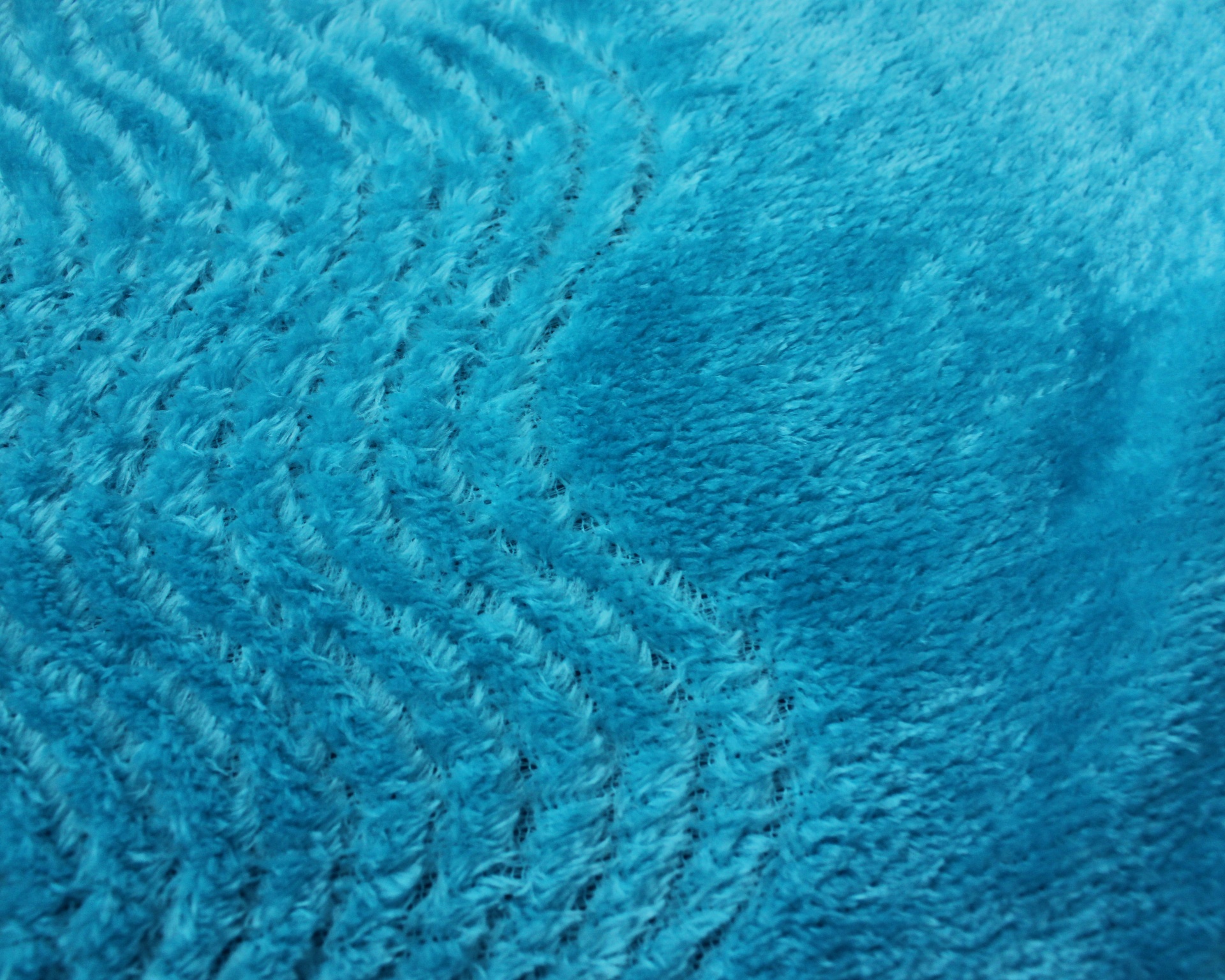 Tapete azul felpudo com padrões circulares e ondulados