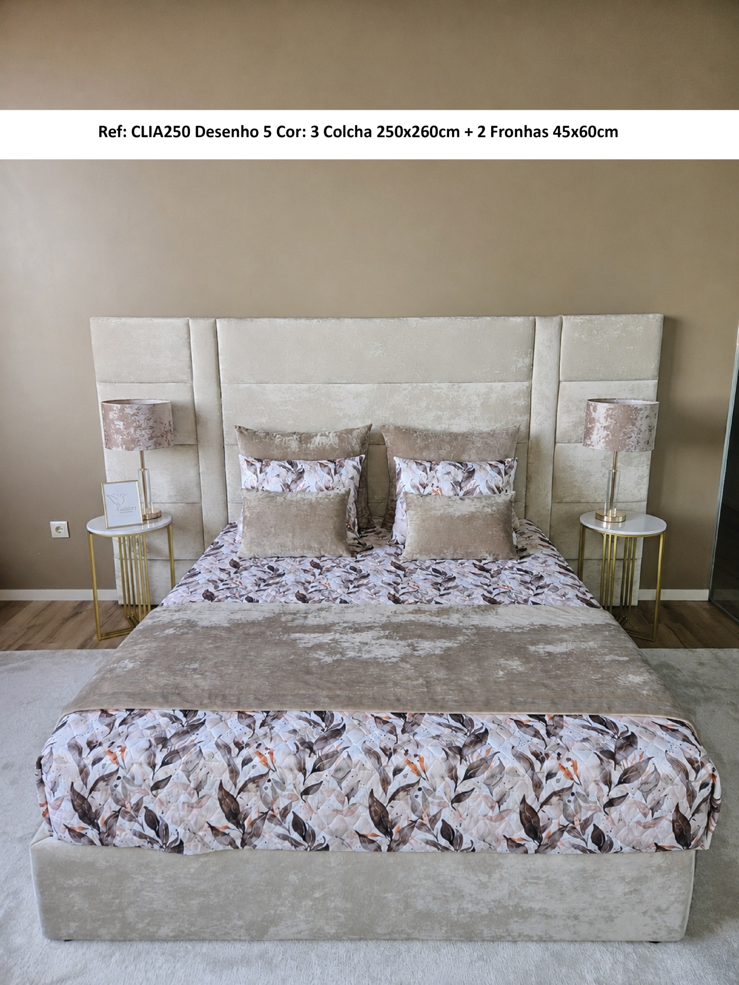 Colcha floral castanha e bege em cama com cabeceira estofada clara num quarto