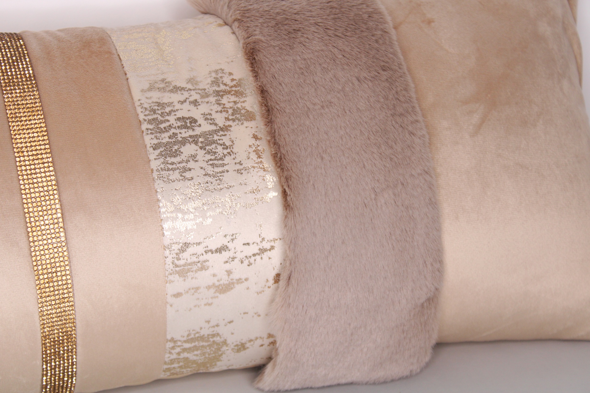 Três almofadas decorativas em tons neutros com diferentes texturas