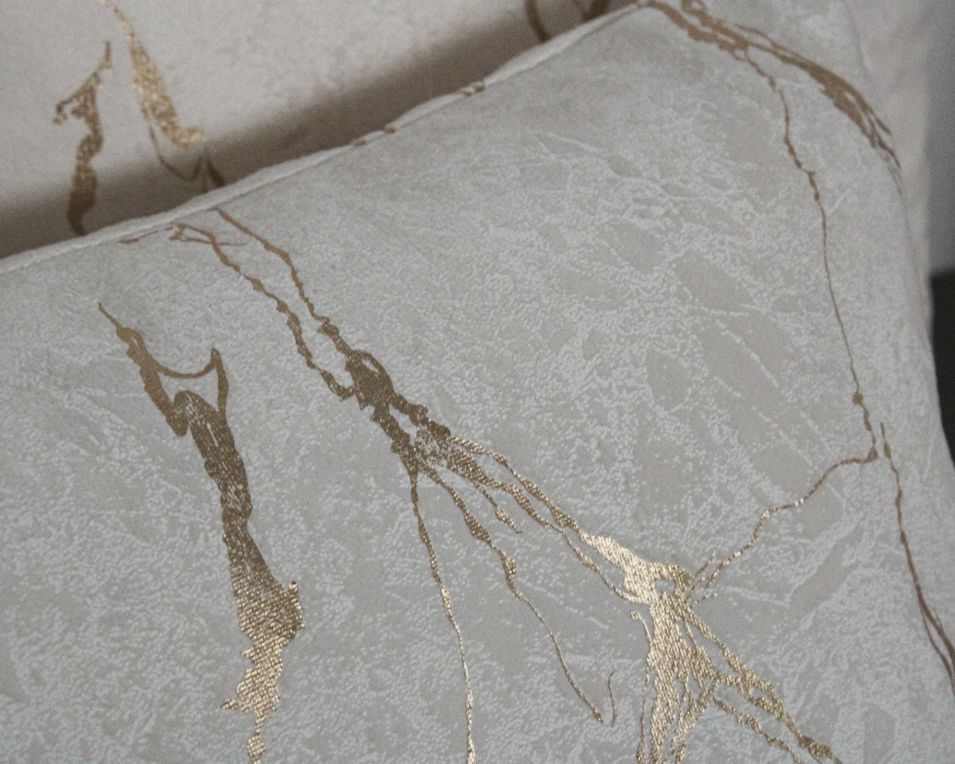 Almofadas cinza com padrão dourado abstrato