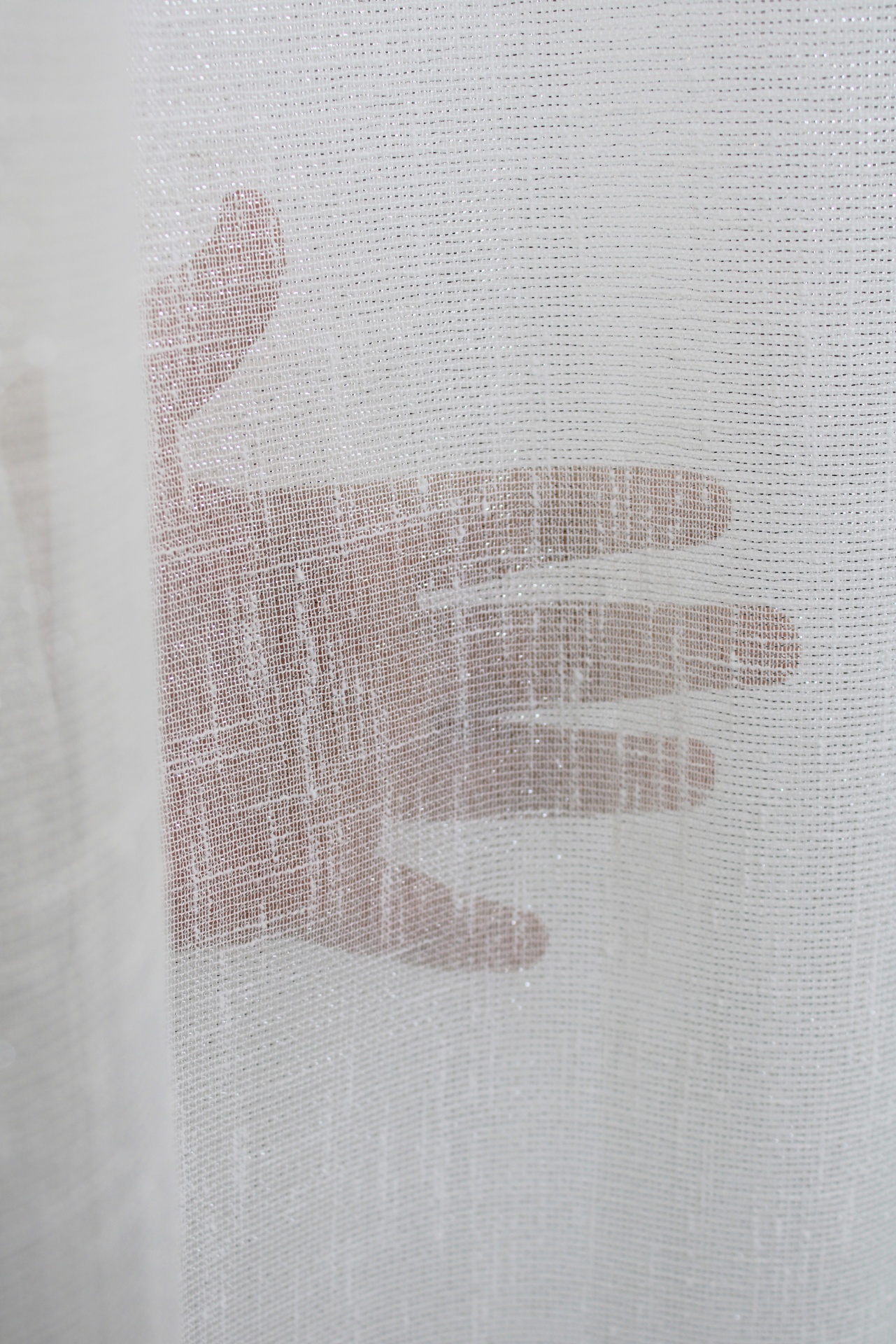 Mão vista através de tecido branco translúcido com trama fina