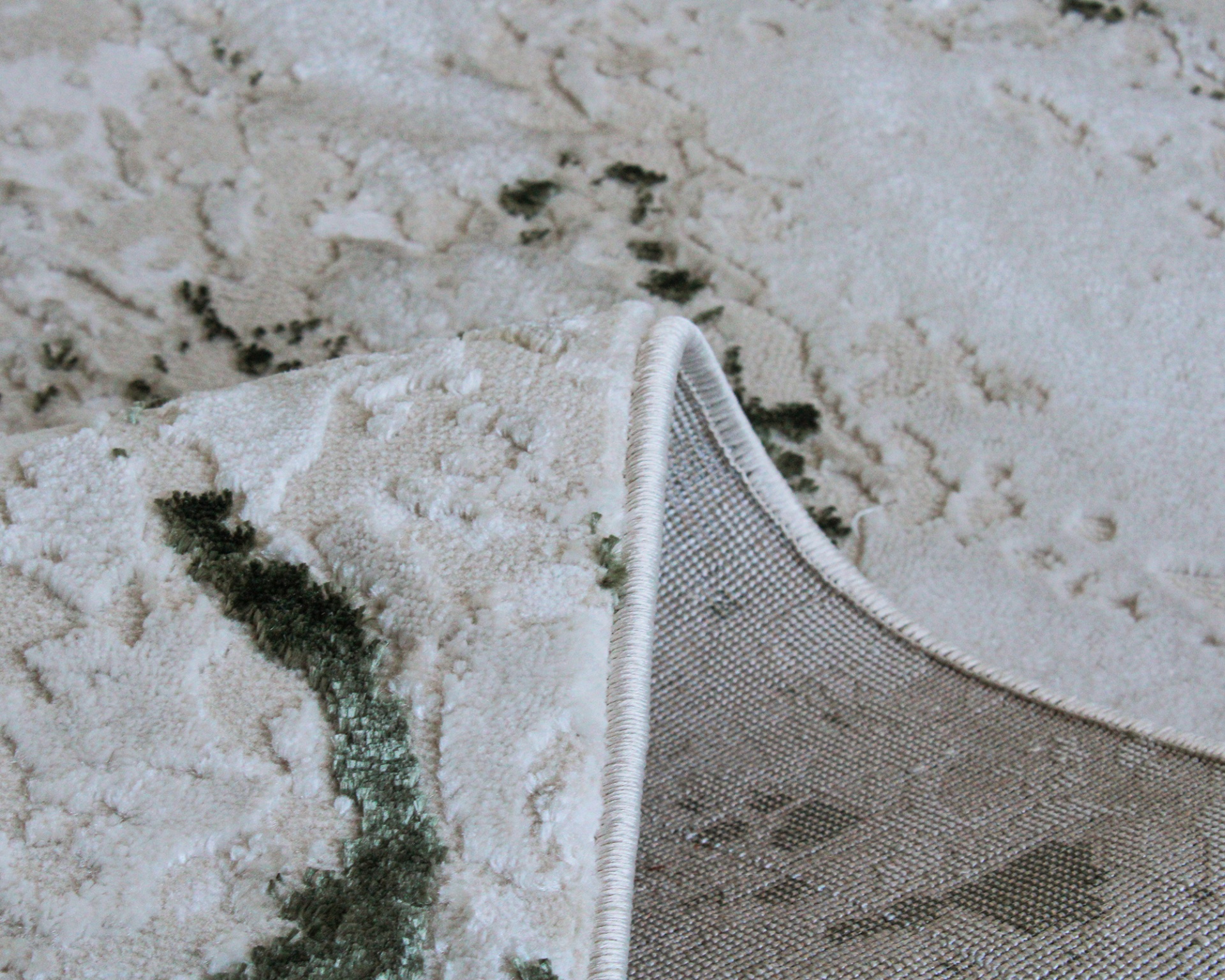 Tapete bege com padrão verde e textura felpuda, parte inferior de trama têxtil.