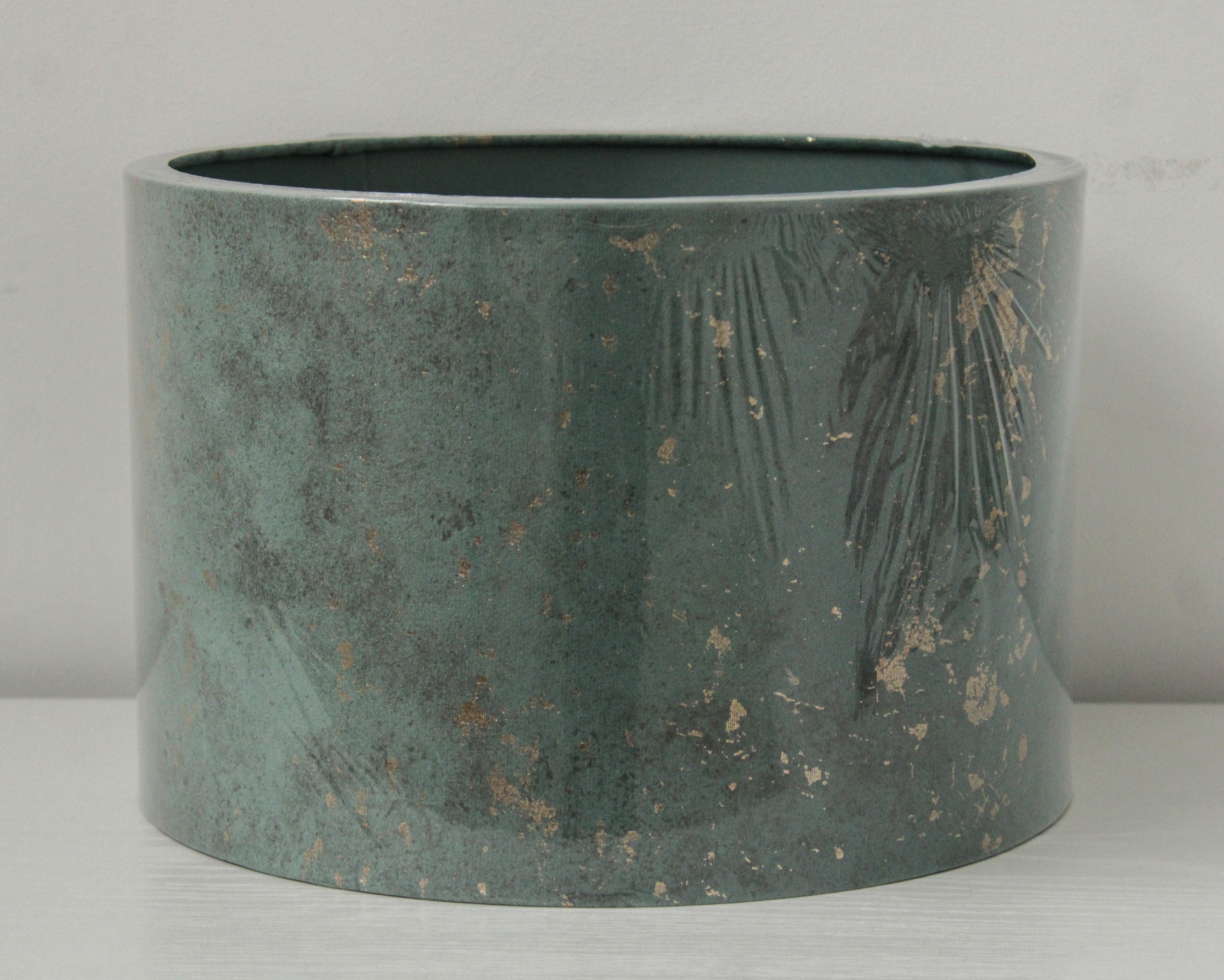 Vaso cerâmico verde escuro com padrão marmoreado em superfície branca