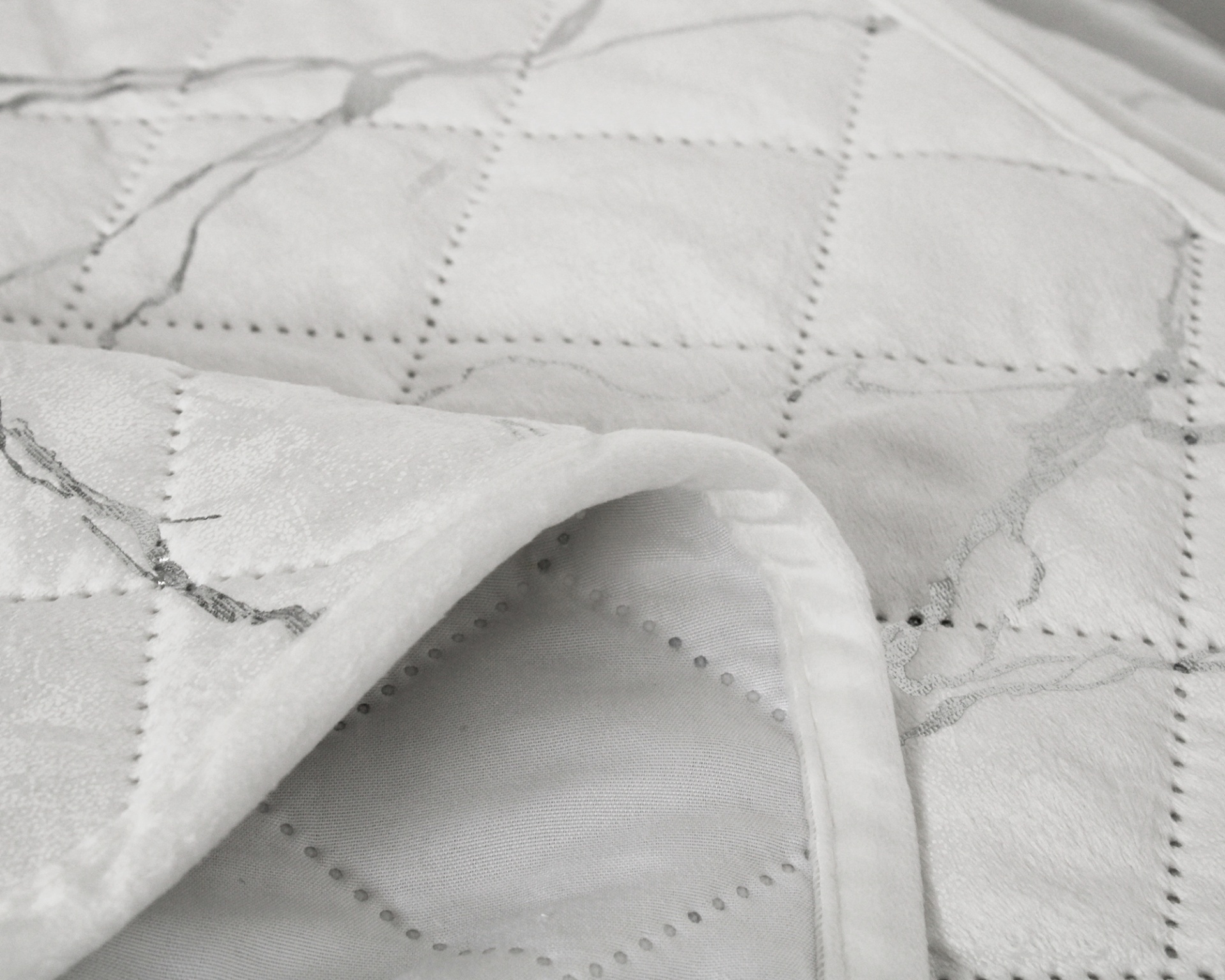 Colcha branca com padrão em quadrados e detalhes cinza