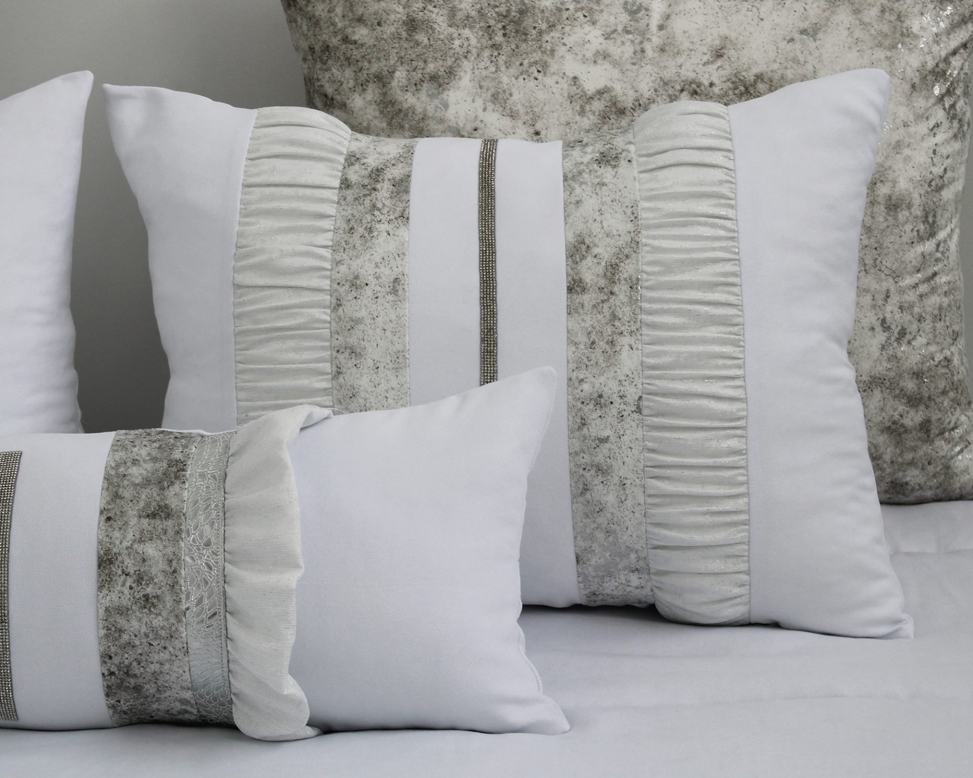 Conjunto de almofadas decorativas em branco e cinza com texturas e padrões