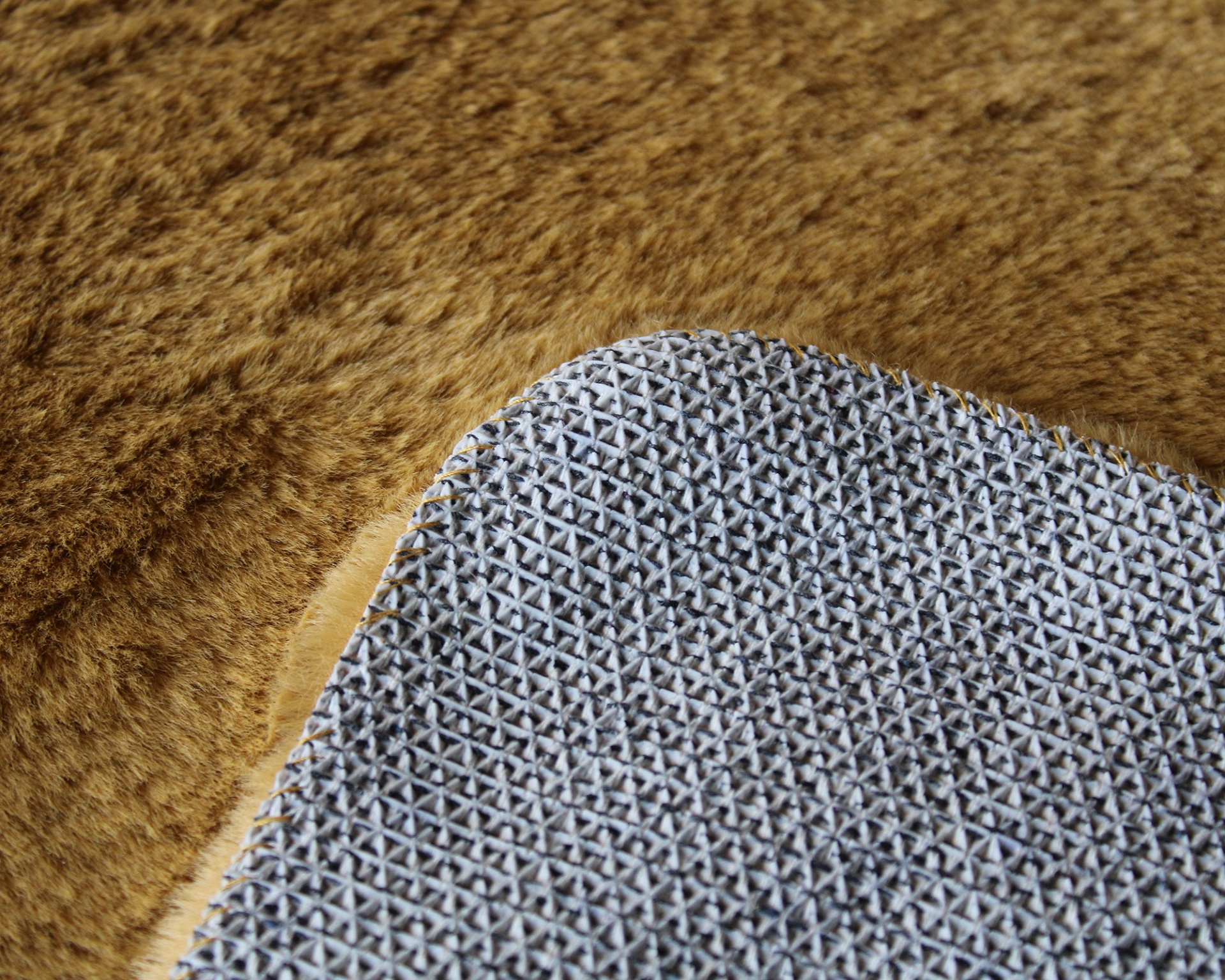 Tapete cinza com padrão antideslizante em cruz sobre pele castanha