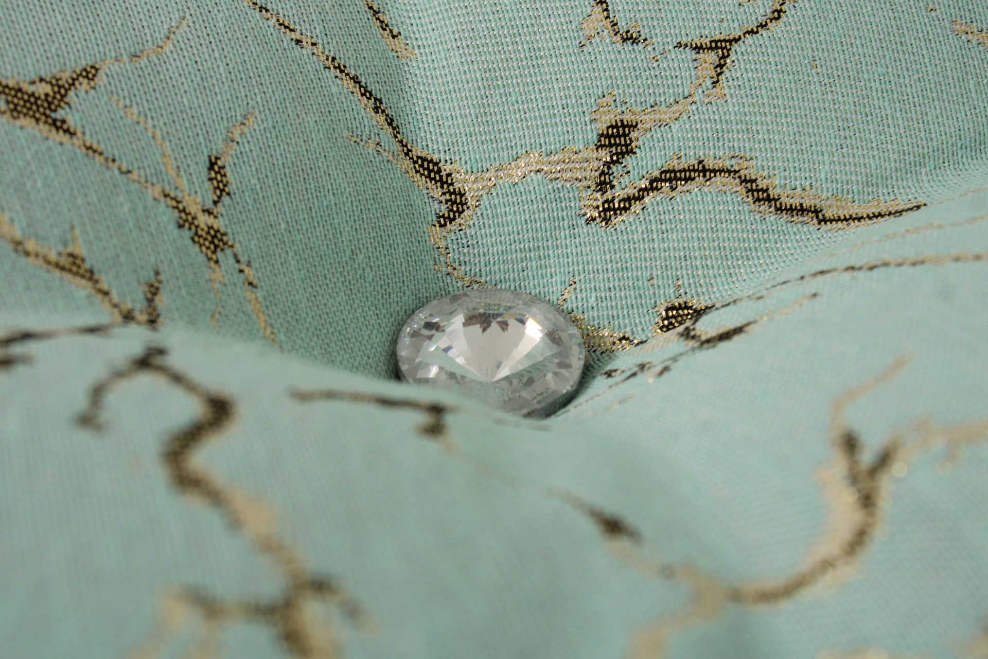 Botão cristal facetado em tecido azul claro com padrão dourado