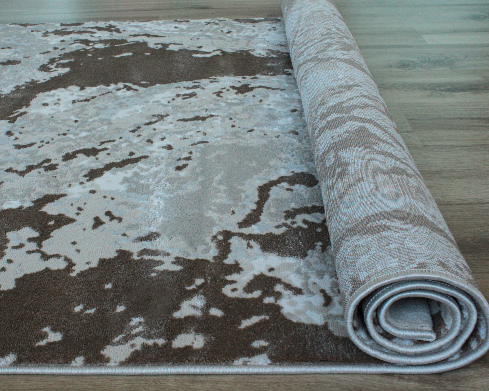 Tapete enrolado castanho e bege com padrão abstrato