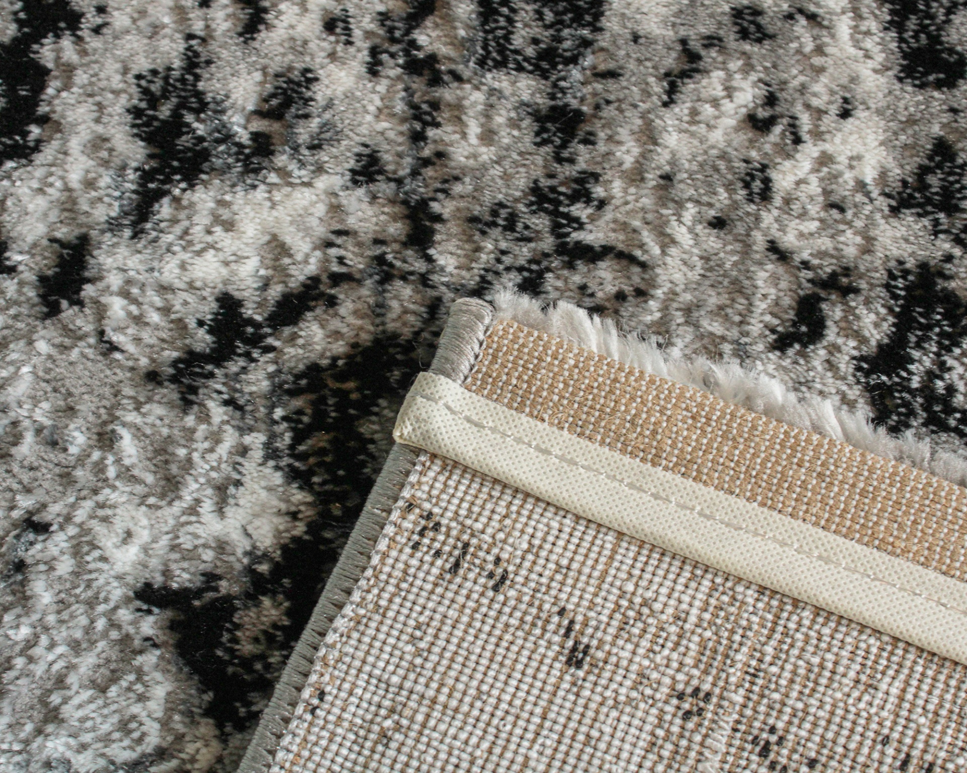 tapete cinza com padrões abstratos e verso tecido bege