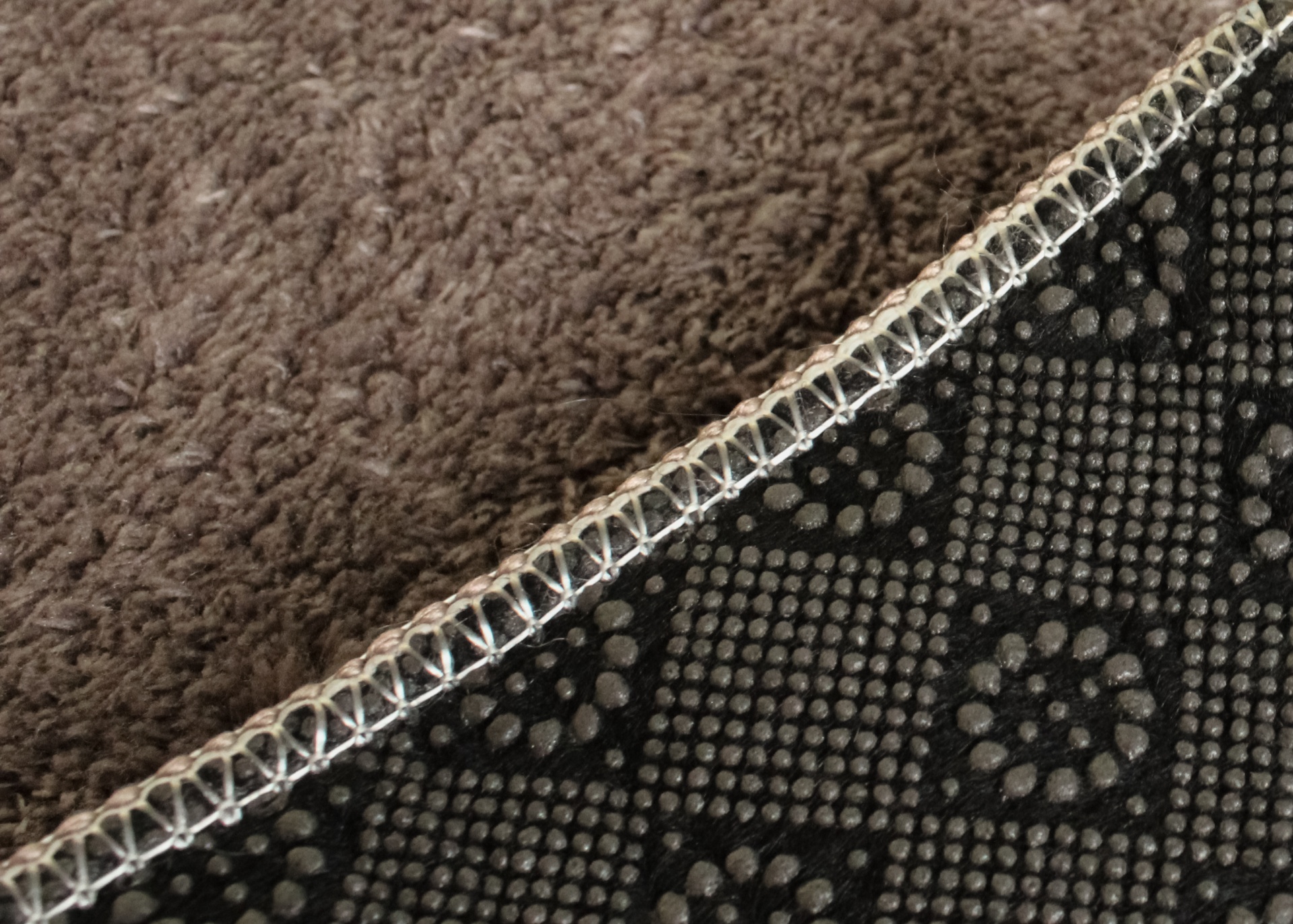 Manta com lado macio castanho e lado antiderrapante preto com padrão de pontos