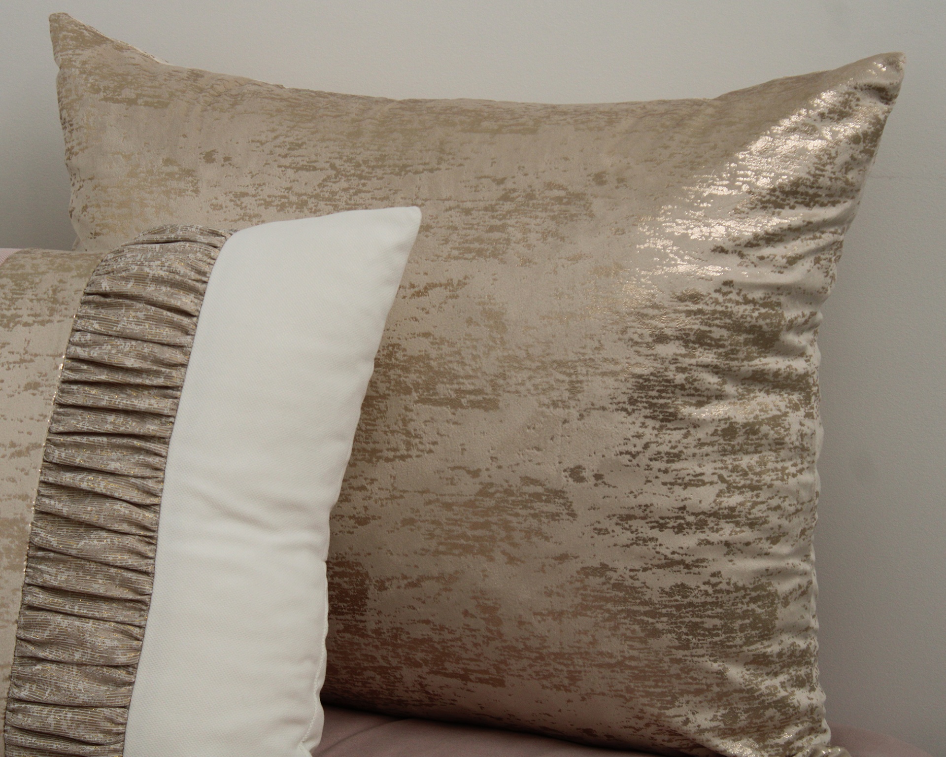 Almofadas decorativas bege e branca com texturas e padrões distintos