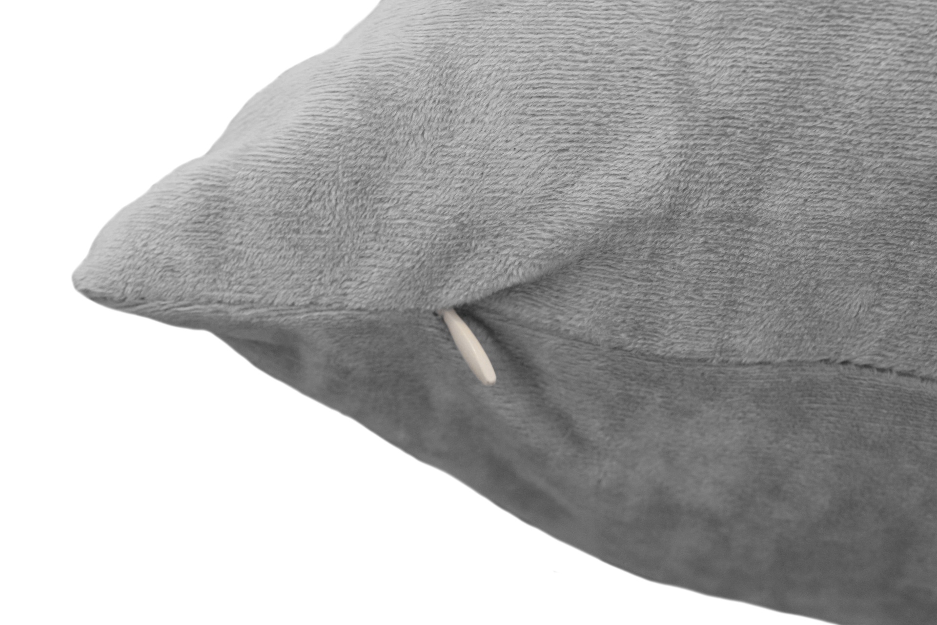 Almofada cinzenta suave com fecho branco num canto.