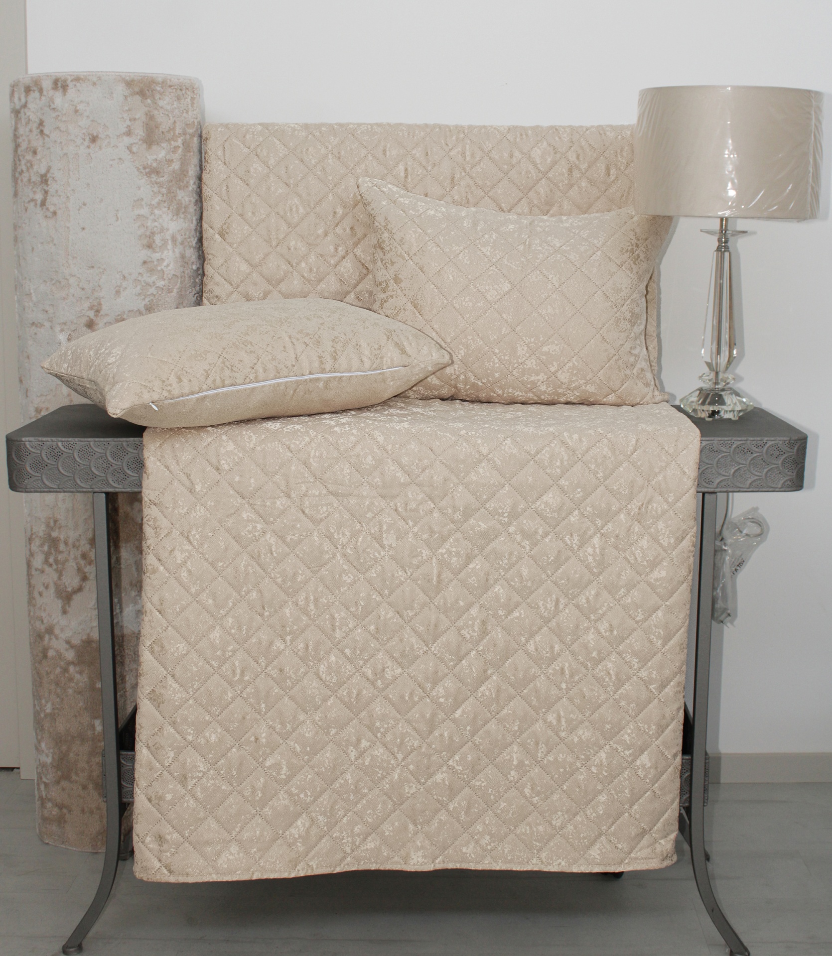 Conjunto têxtil bege claro matelassado com mesa cinza e candeeiro