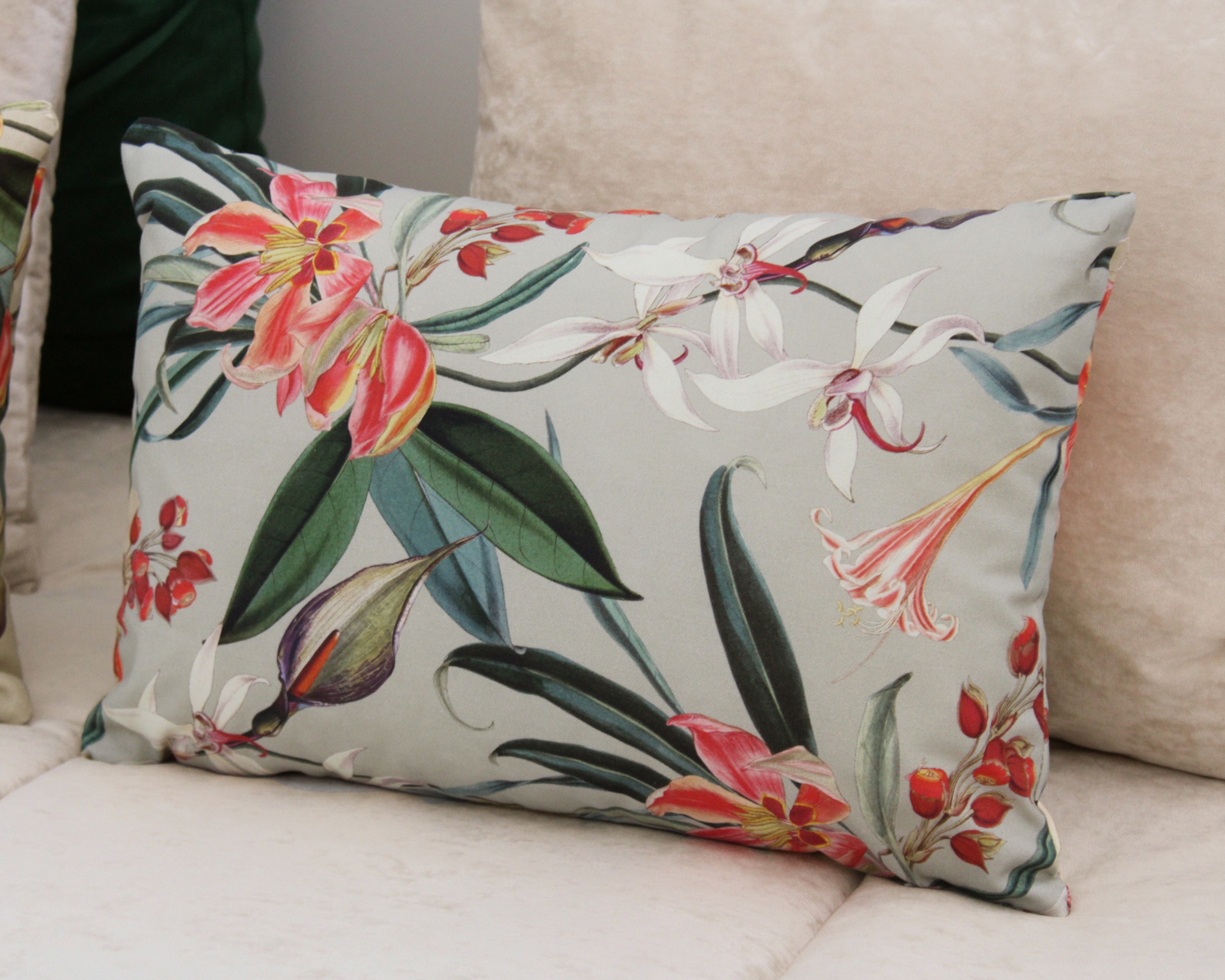 Almofada rectangular floral colorida em sofá bege.