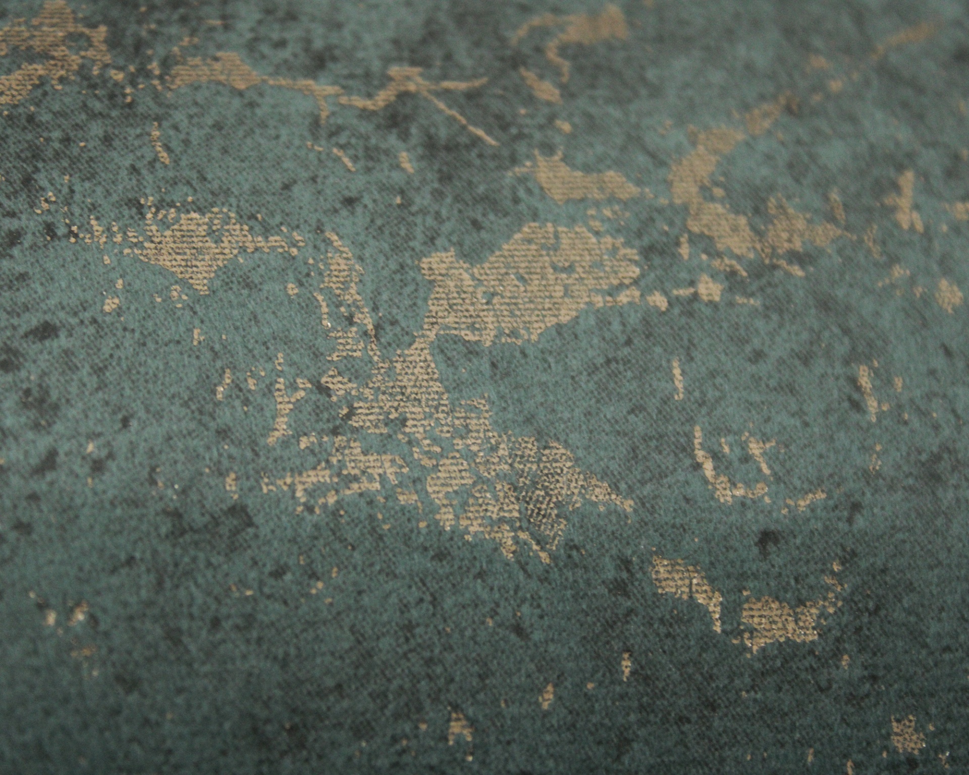 Tecido verde com padrões dourados irregulares e textura rugosa